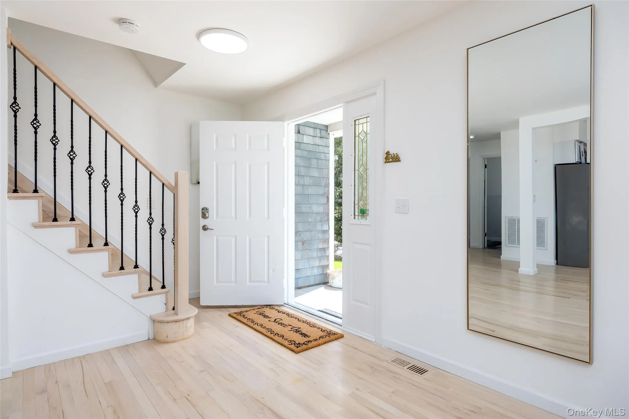 Entrance foyer featuring wood finished floors, stairs, and baseboards Entrance foyer featuring wood finished floors, stairs, and baseboards