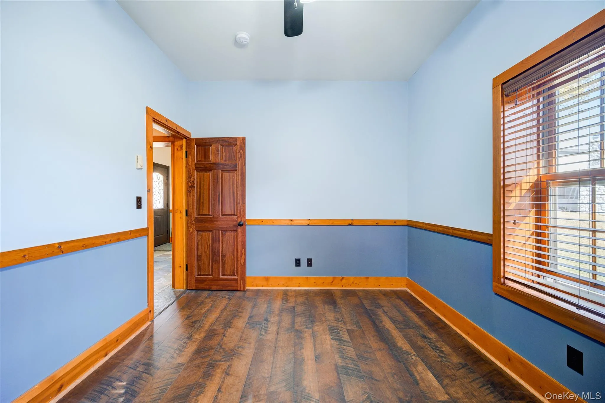 Unfurnished room with ceiling fan and dark wood-type flooring Unfurnished room with ceiling fan and dark wood-type flooring