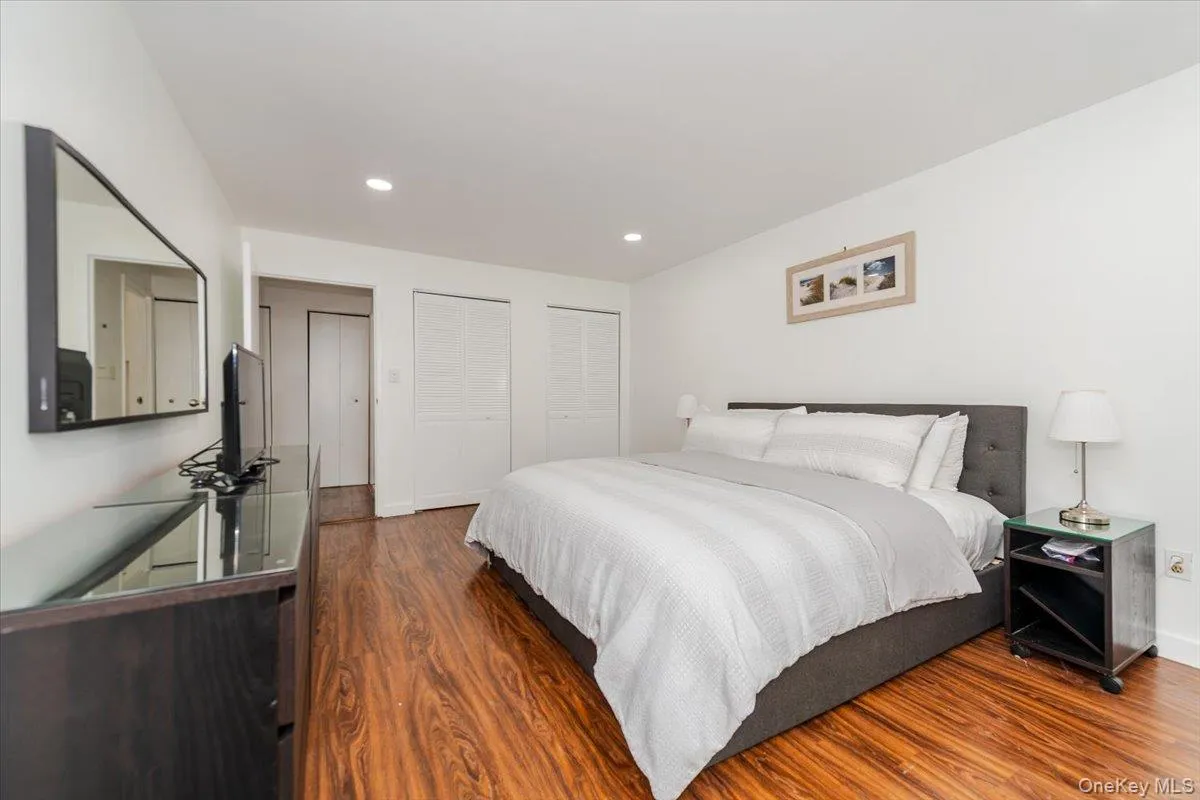 Bedroom with wood finished floors, multiple closets, and recessed lighting Bedroom with wood finished floors, multiple closets, and recessed lighting