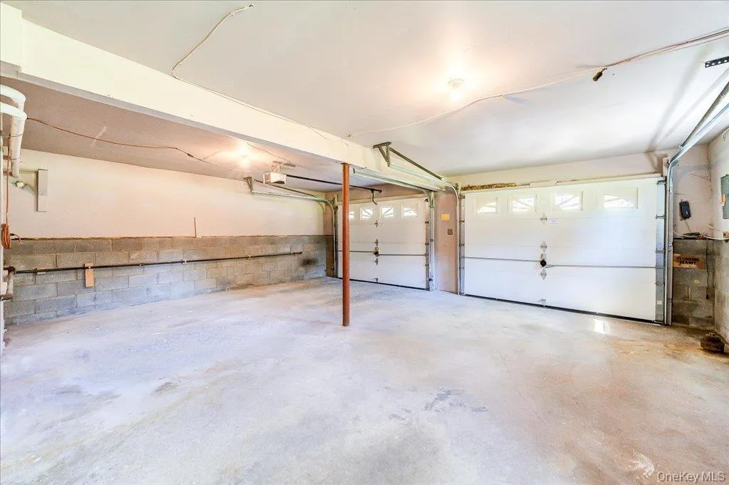 Two-car garage with concrete flooring and white panel doors Two-car garage with concrete flooring and white panel doors