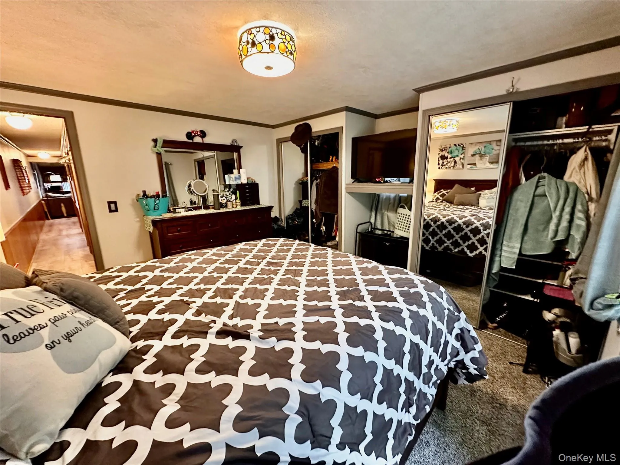 Primary Bedroom carpeted flooring with a decorative ceiling light fixture. Primary Bedroom carpeted flooring with a decorative ceiling light fixture.