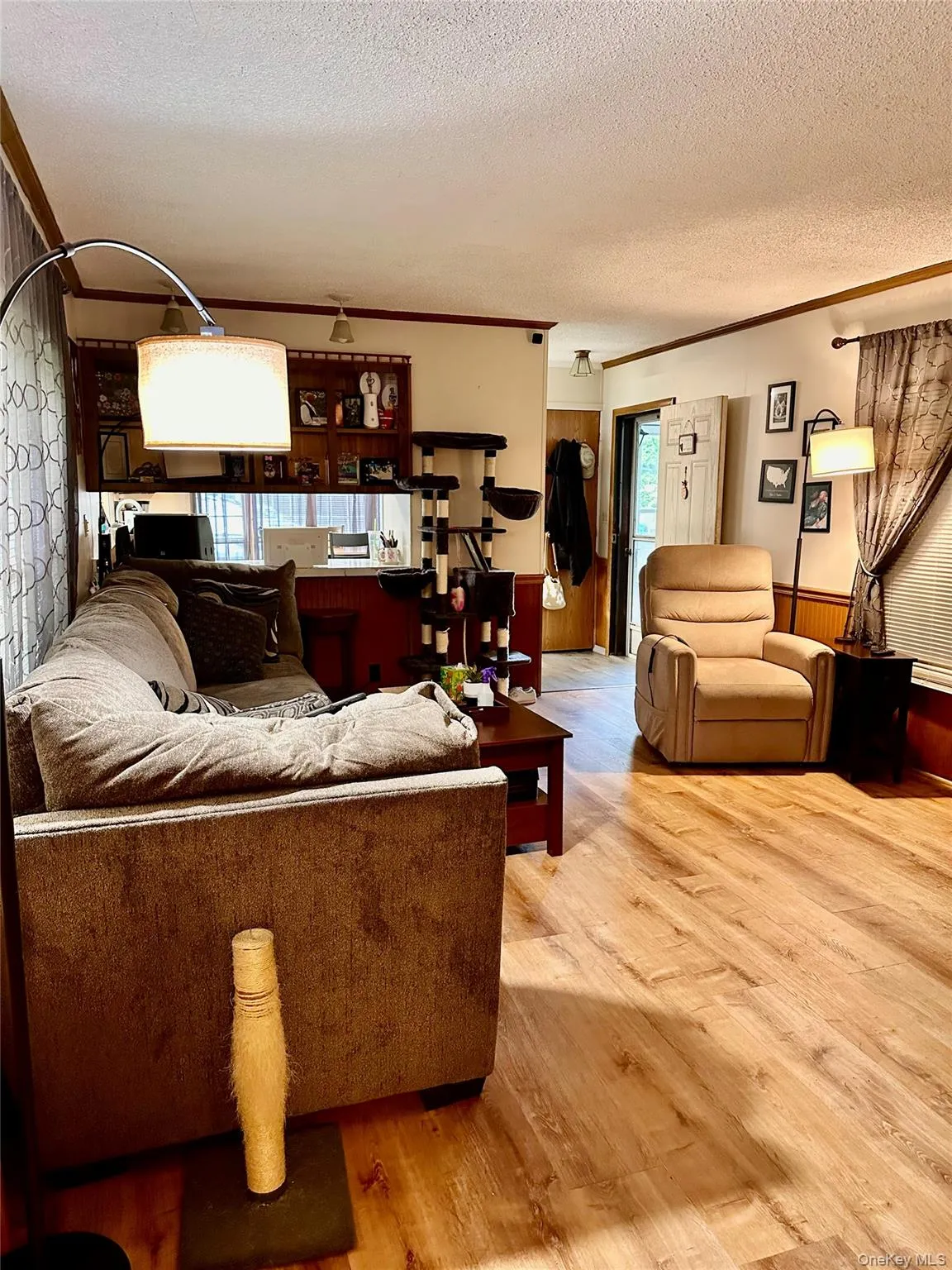 Open concept living area with wood-finish flooring, recessed lighting, and a built-in display shelf. Open concept living area with wood-finish flooring, recessed lighting, and a built-in display shelf.