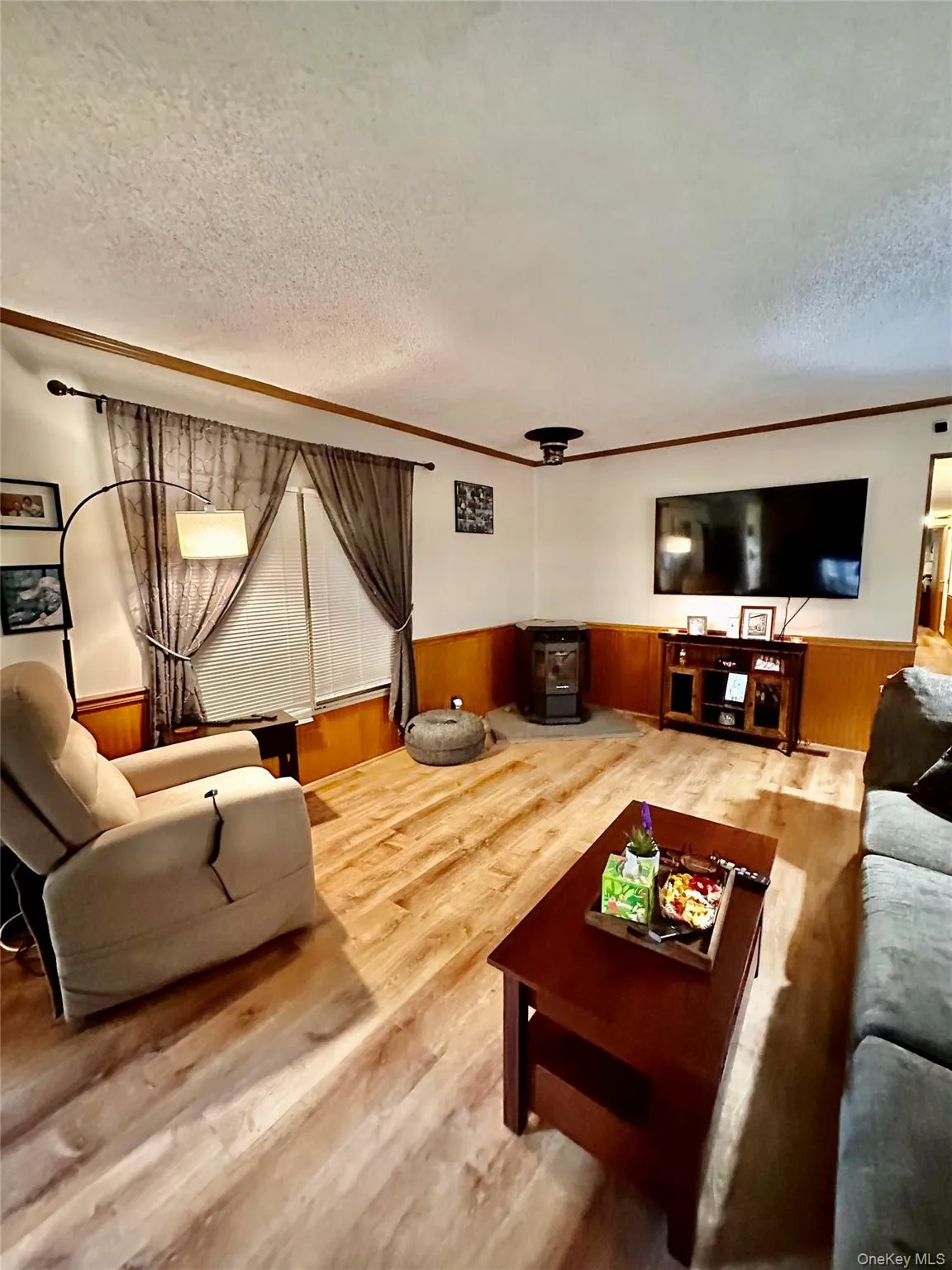 Wood-finish flooring, wainscoting, and a ceiling-mounted light fixture. Wood-finish flooring, wainscoting, and a ceiling-mounted light fixture.