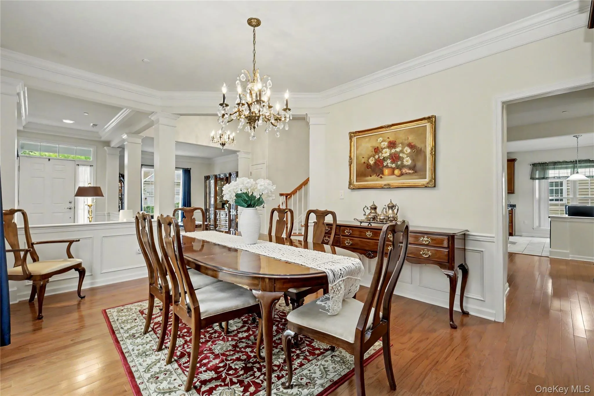 Hardwood flooring, decorative wainscoting, crown molding, and a crystal chandelier Hardwood flooring, decorative wainscoting, crown molding, and a crystal chandelier