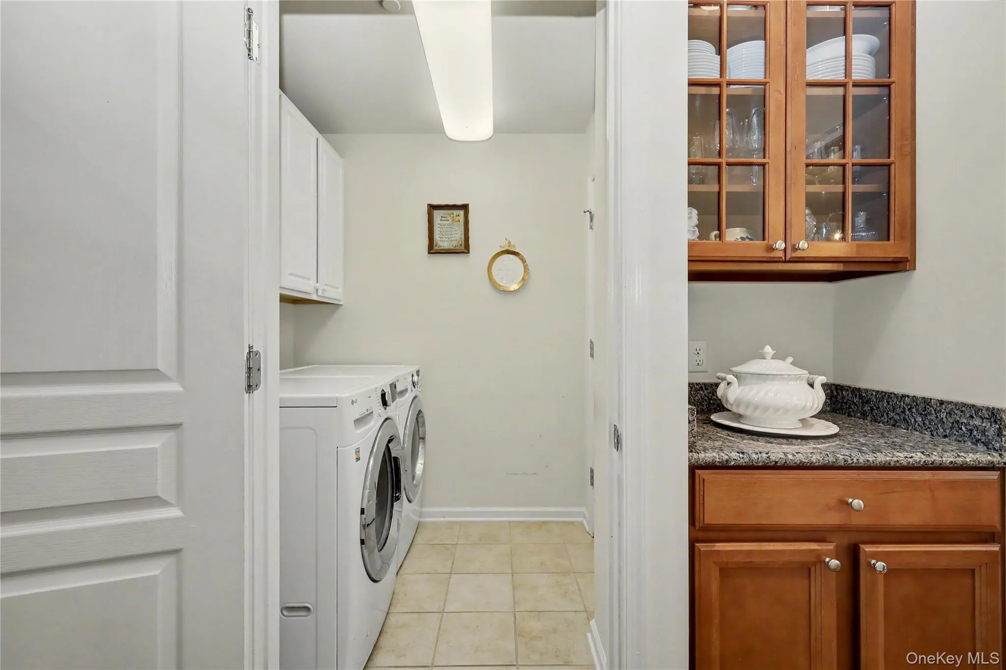 Laundry area with tile flooring, butler's pantry with cabinetry Laundry area with tile flooring, butler's pantry with cabinetry
