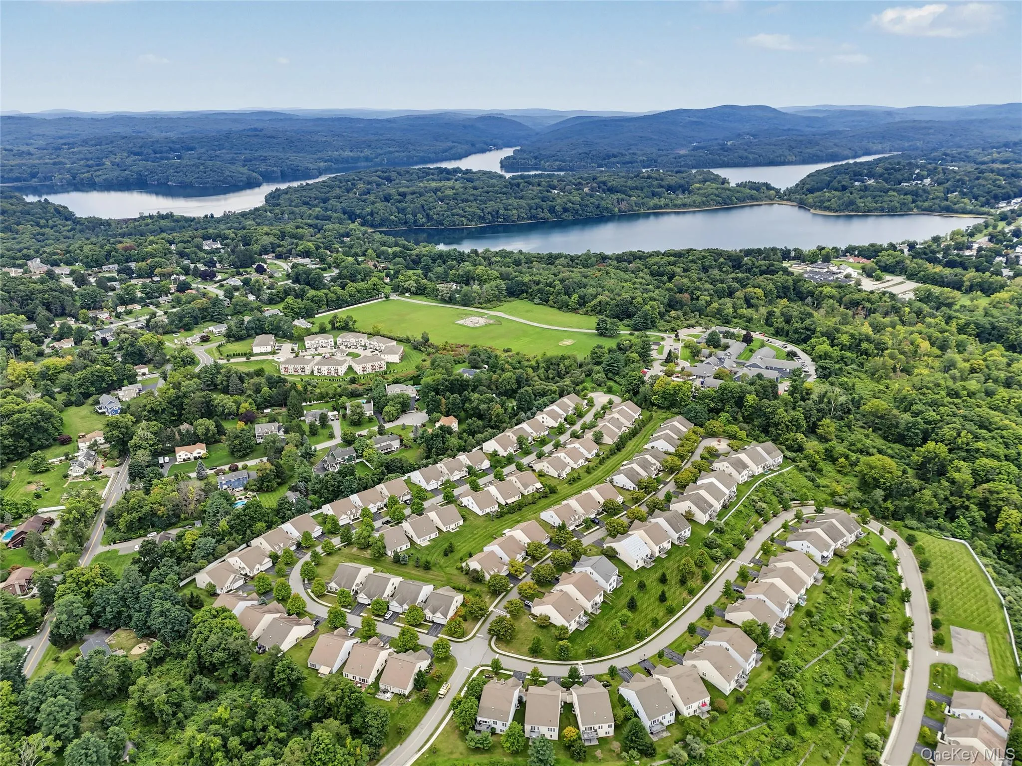 Residential development with uniform housing, surrounded by extensive green spaces and mature trees Residential development with uniform housing, surrounded by extensive green spaces and mature trees