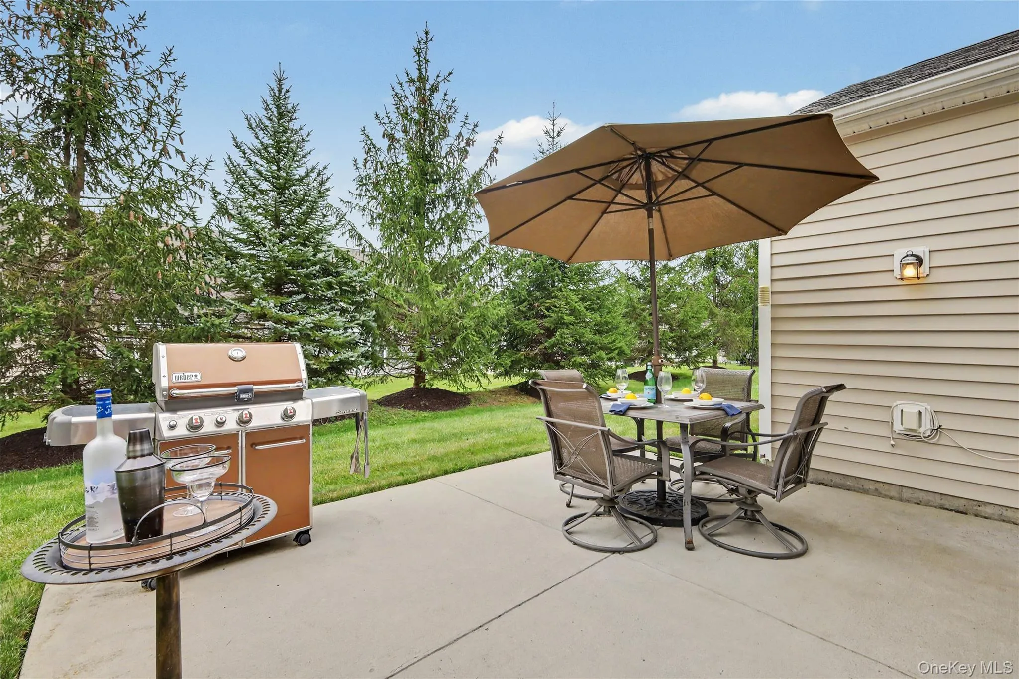 Concrete patio with a wall-mounted exterior light fixture and siding Concrete patio with a wall-mounted exterior light fixture and siding