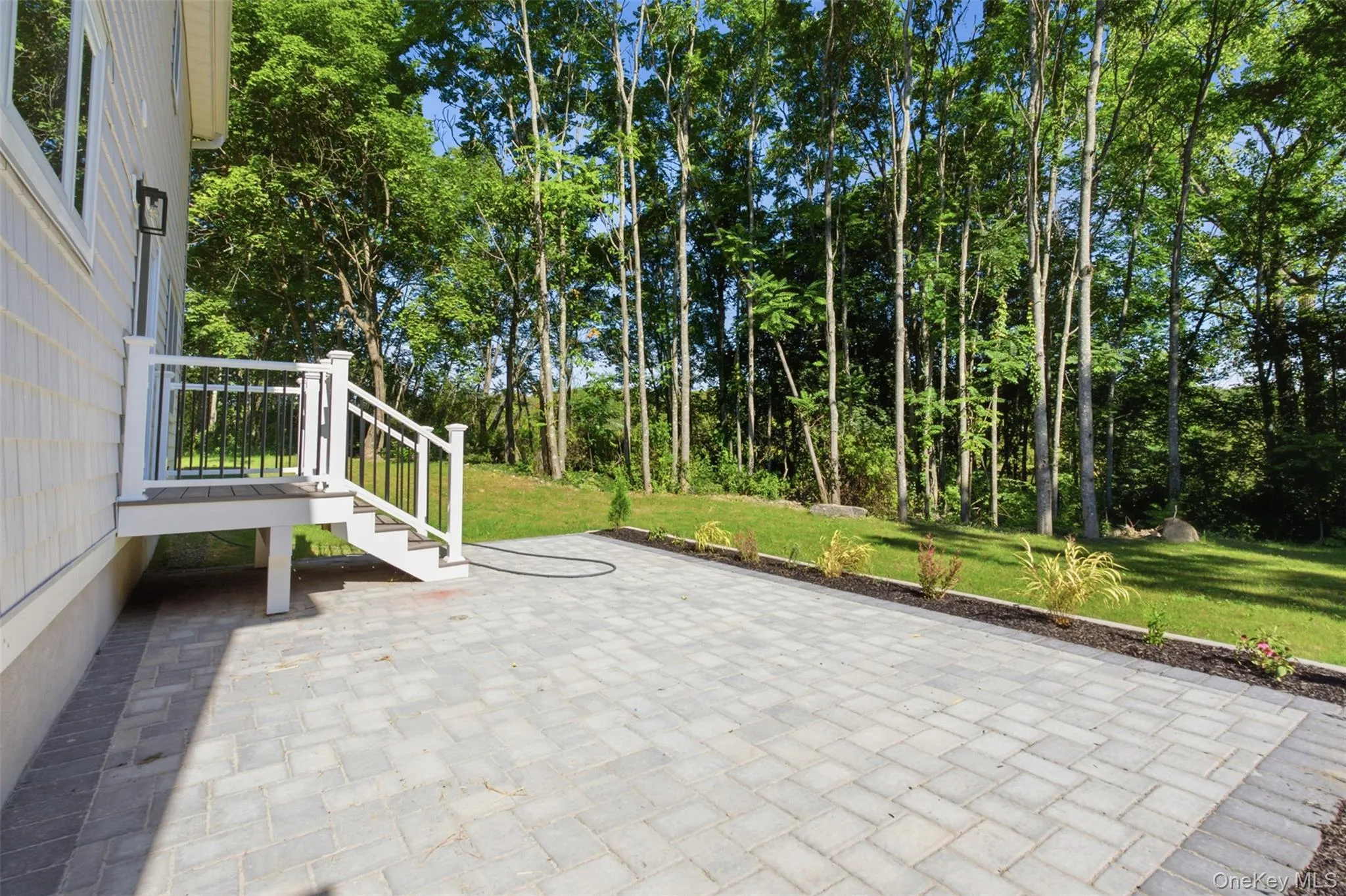 Paver patio with a white-railed deck and steps Paver patio with a white-railed deck and steps