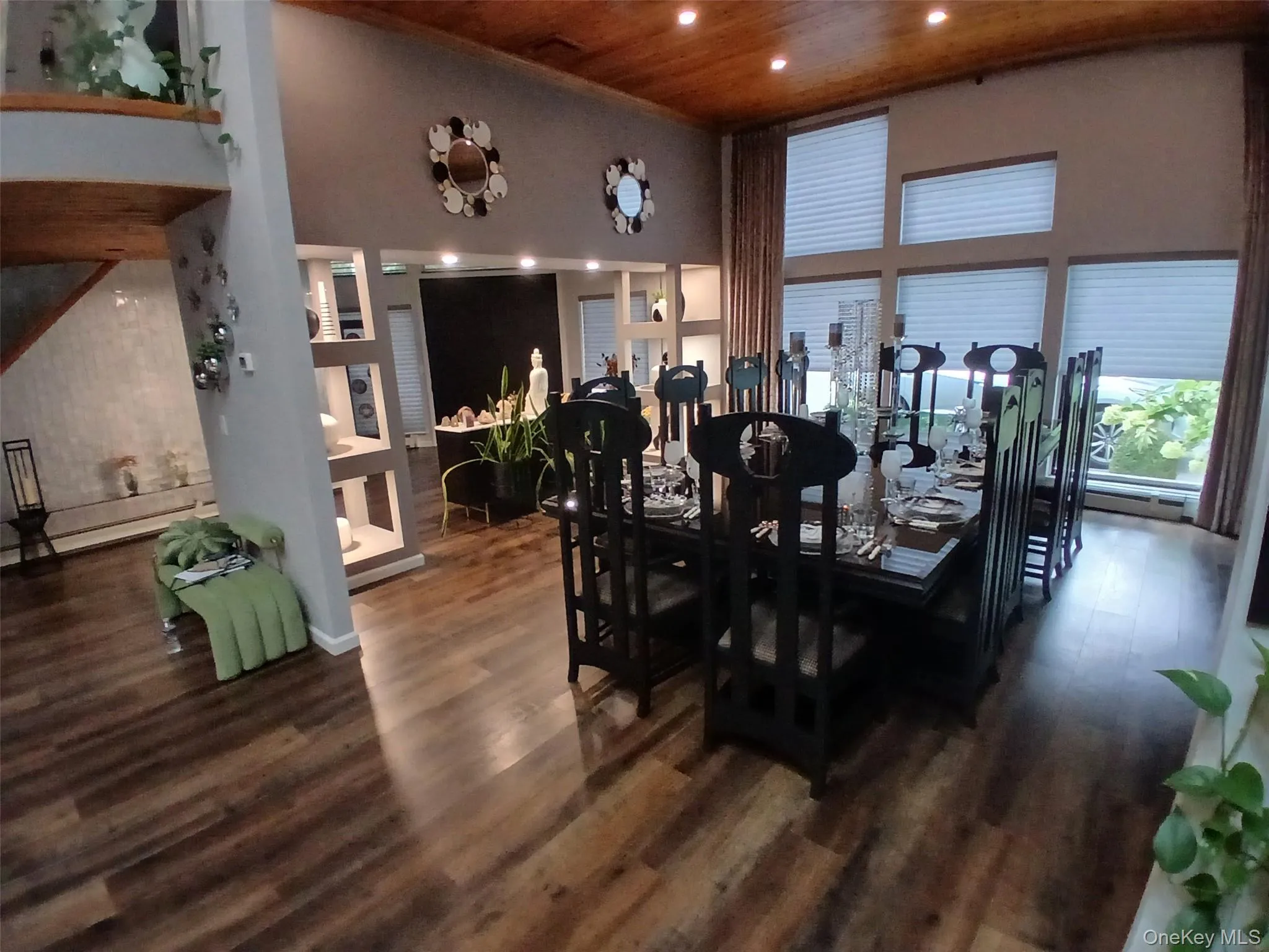 Vaulted wood-paneled ceiling, recessed lighting, expansive window array, wood-finish flooring, and built-in shelving Vaulted wood-paneled ceiling, recessed lighting, expansive window array, wood-finish flooring, and built-in shelving