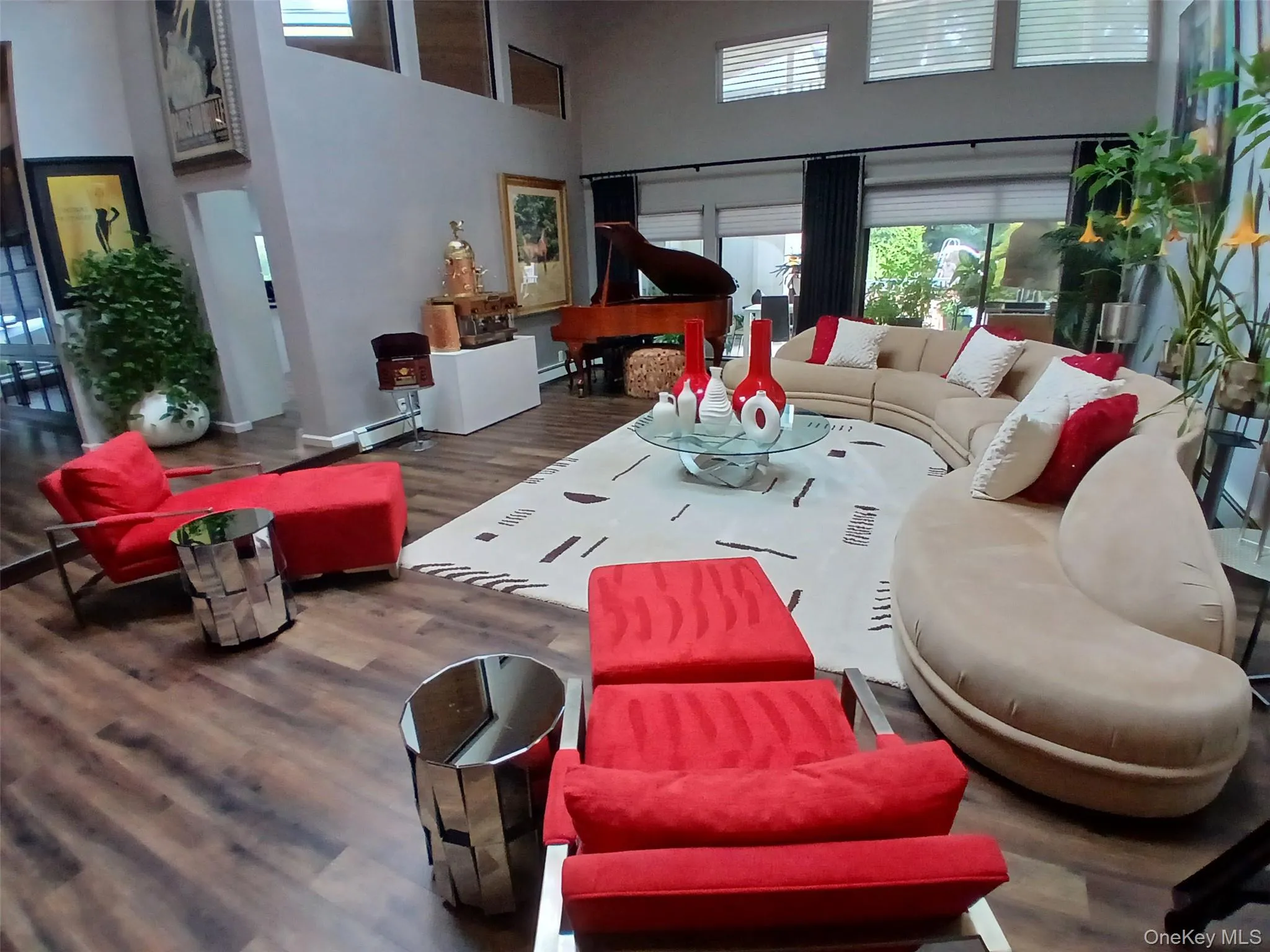 Vaulted ceilings, wood-finish flooring, a large area rug, and expansive windows Vaulted ceilings, wood-finish flooring, a large area rug, and expansive windows