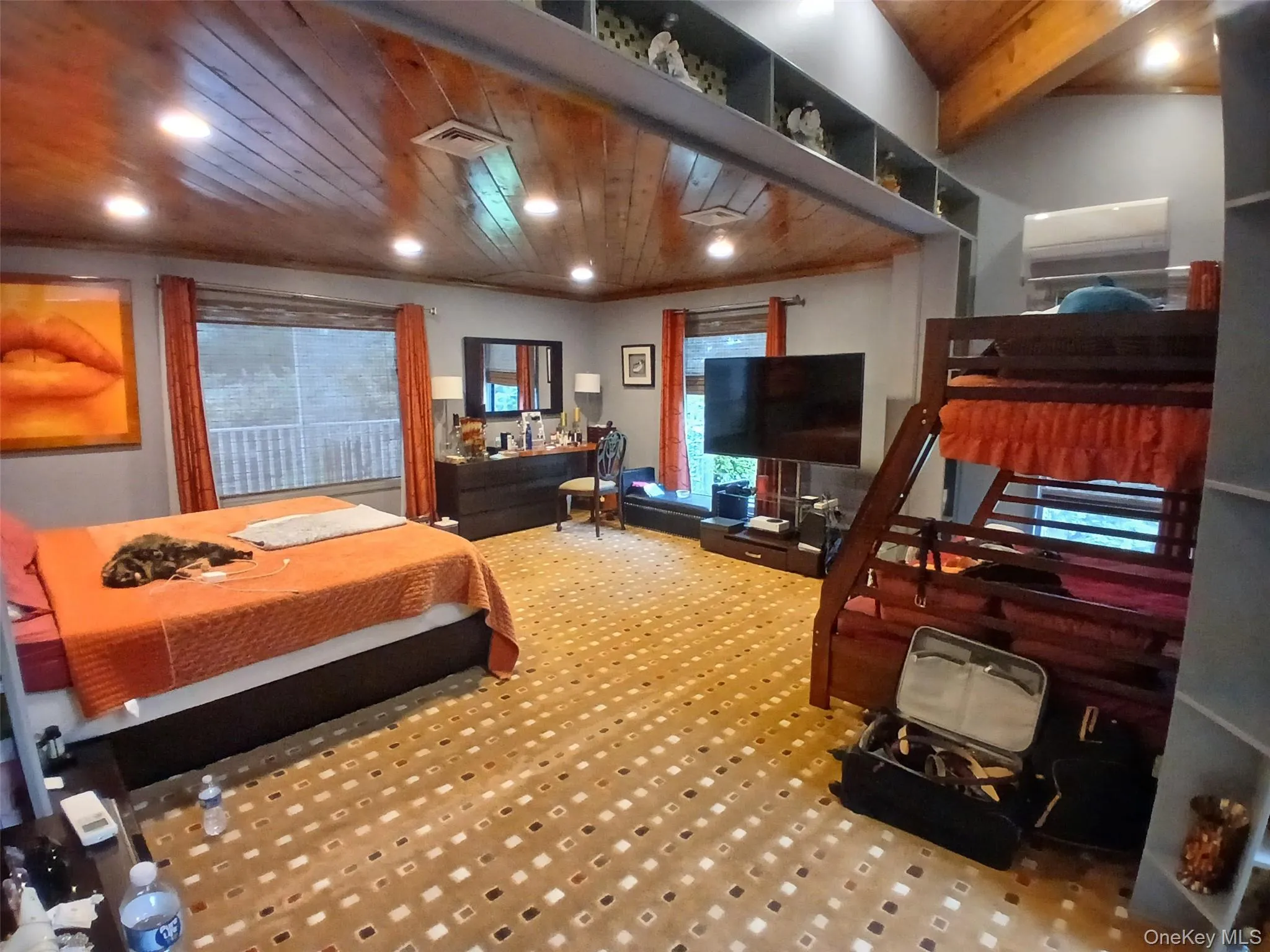 Wood-paneled vaulted ceiling with recessed lighting, integrated shelving, and wall-mounted air conditioning unit Wood-paneled vaulted ceiling with recessed lighting, integrated shelving, and wall-mounted air conditioning unit
