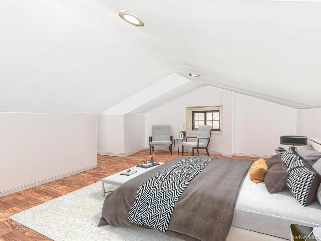 Bedroom featuring light hardwood / wood-style flooring and lofted ceiling Bedroom featuring light hardwood / wood-style flooring and lofted ceiling