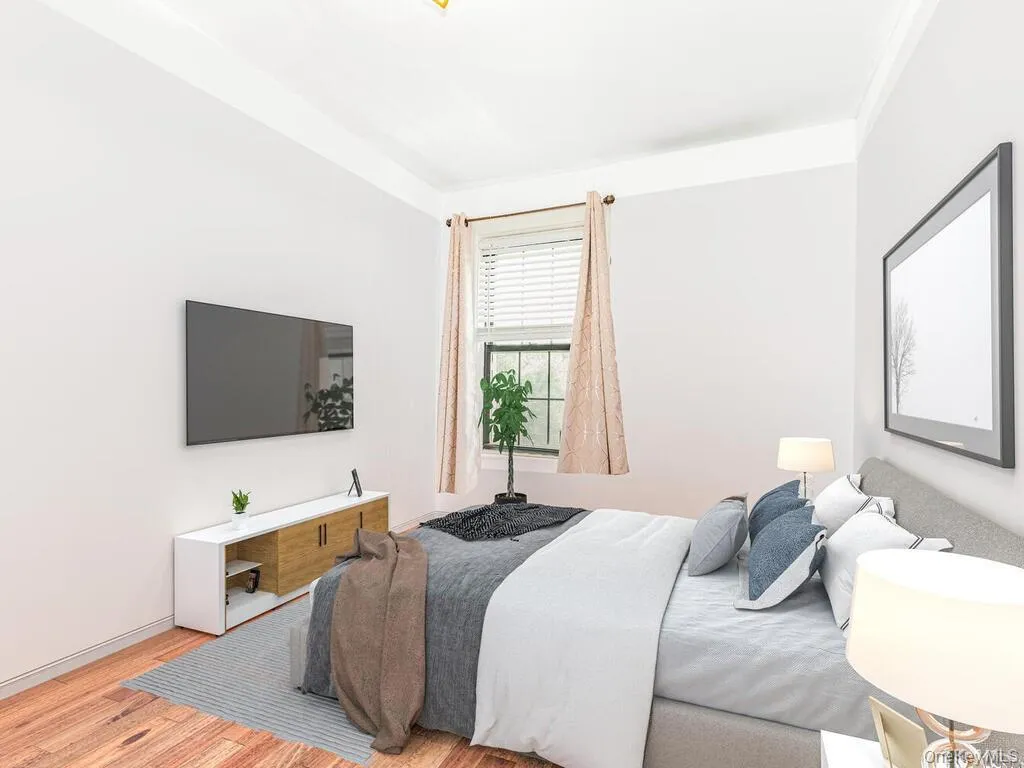 Bedroom with light hardwood / wood-style floors and crown molding Bedroom with light hardwood / wood-style floors and crown molding