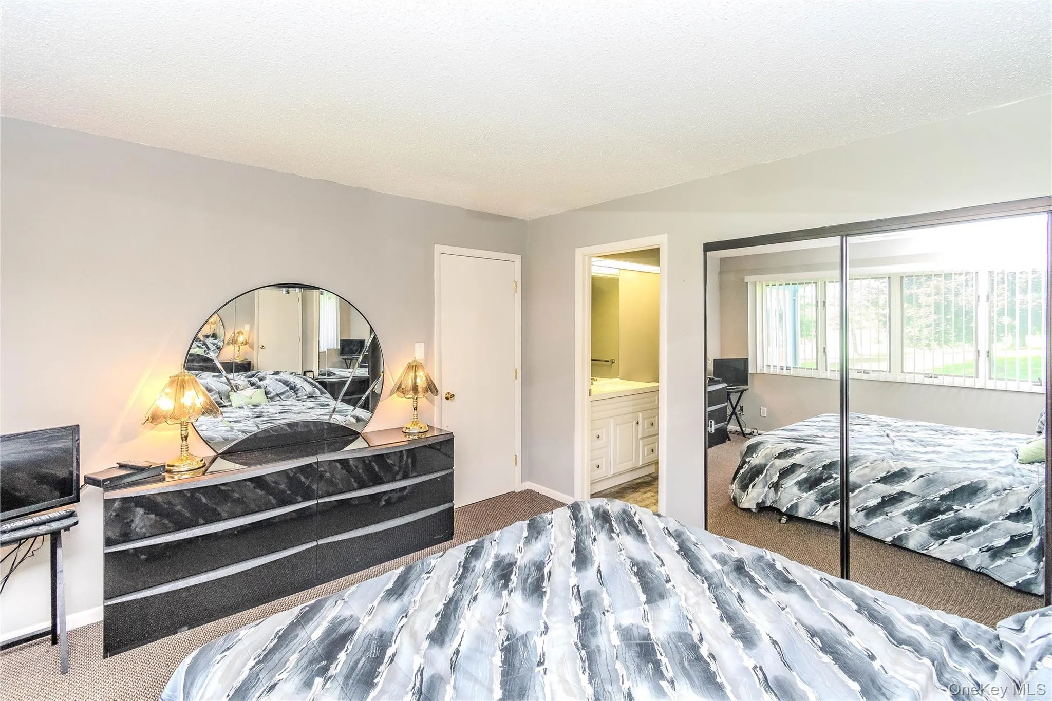 Mirrored closet doors, light gray wall paint, and a white interior door Mirrored closet doors, light gray wall paint, and a white interior door
