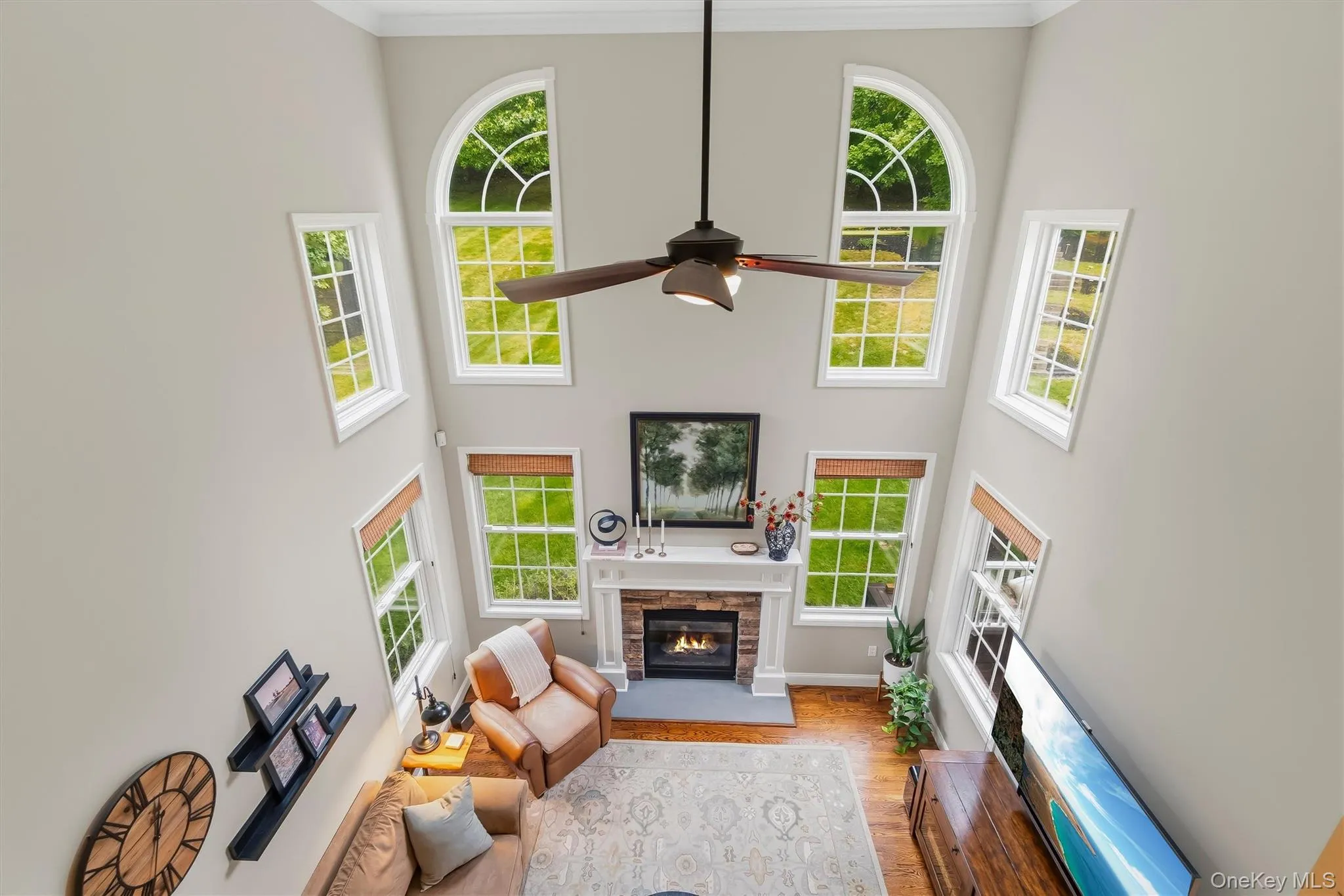 From above, the grandeur of this expansive family room truly comes into focus. The cathedral ceiling soars overhead, framing the dramatic stacked-stone fireplace—a stunning centerpiece visible from multiple vantage points throughout the open-concept living space. Accented by a stately wood mantel, the 36-inch gas fireplace creates warmth and visual impact. The room’s scale, flow, and thoughtful design make it ideal for entertaining, with effortless connections to the kitchen and eat-in area below. This breathtaking space is the heart of the home—inviting, elegant, and designed for memorable gatherings. From above, the grandeur of this expansive family room truly comes into focus. The cathedral ceiling soars overhead, framing the dramatic stacked-stone fireplace—a stunning centerpiece visible from multiple vantage points throughout the open-concept living space. Accented by a stately wood mantel, the 36-inch gas fireplace creates warmth and visual impact. The room’s scale, flow, and thoughtful design make it ideal for entertaining, with effortless connections to the kitchen and eat-in area below. This breathtaking space is the heart of the home—inviting, elegant, and designed for memorable gatherings.