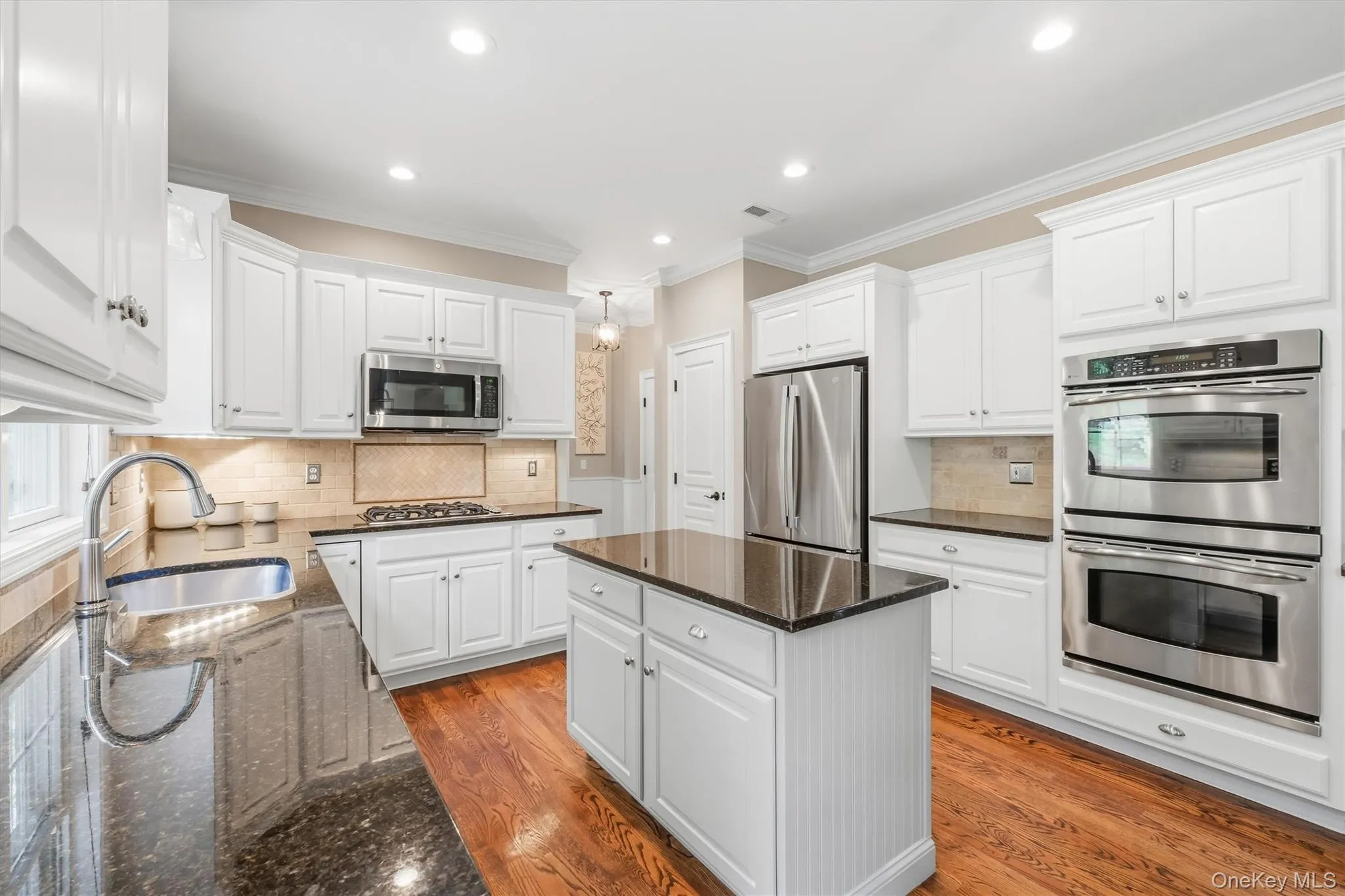 This kitchen is a true showpiece—an entertainer’s dream that effortlessly blends refined elegance with everyday functionality. Gleaming hardwood floors flow throughout the open-concept space, beautifully reflecting the natural light that fills every corner. At its heart, a striking center island topped with luxurious Uba Tuba granite creates the perfect gathering place for casual conversation, meal preparation, and memorable moments with friends and family. This kitchen is a true showpiece—an entertainer’s dream that effortlessly blends refined elegance with everyday functionality. Gleaming hardwood floors flow throughout the open-concept space, beautifully reflecting the natural light that fills every corner. At its heart, a striking center island topped with luxurious Uba Tuba granite creates the perfect gathering place for casual conversation, meal preparation, and memorable moments with friends and family.