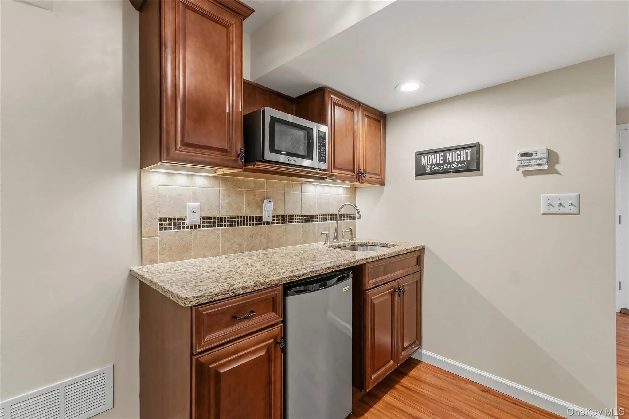 Thoughtfully appointed for comfort and convenience, the lower level features a full bathroom and a well-equipped summer kitchen with custom cabinetry, granite countertops, a microwave, sink, and mini refrigerator. Sleek luxury vinyl flooring, complementary carpeting, and fresh modern paint create a polished, move-in-ready setting. Designed for effortless enjoyment, this inviting space brings together recreation, relaxation, and entertaining in one exceptional retreat. Thoughtfully appointed for comfort and convenience, the lower level features a full bathroom and a well-equipped summer kitchen with custom cabinetry, granite countertops, a microwave, sink, and mini refrigerator. Sleek luxury vinyl flooring, complementary carpeting, and fresh modern paint create a polished, move-in-ready setting. Designed for effortless enjoyment, this inviting space brings together recreation, relaxation, and entertaining in one exceptional retreat.