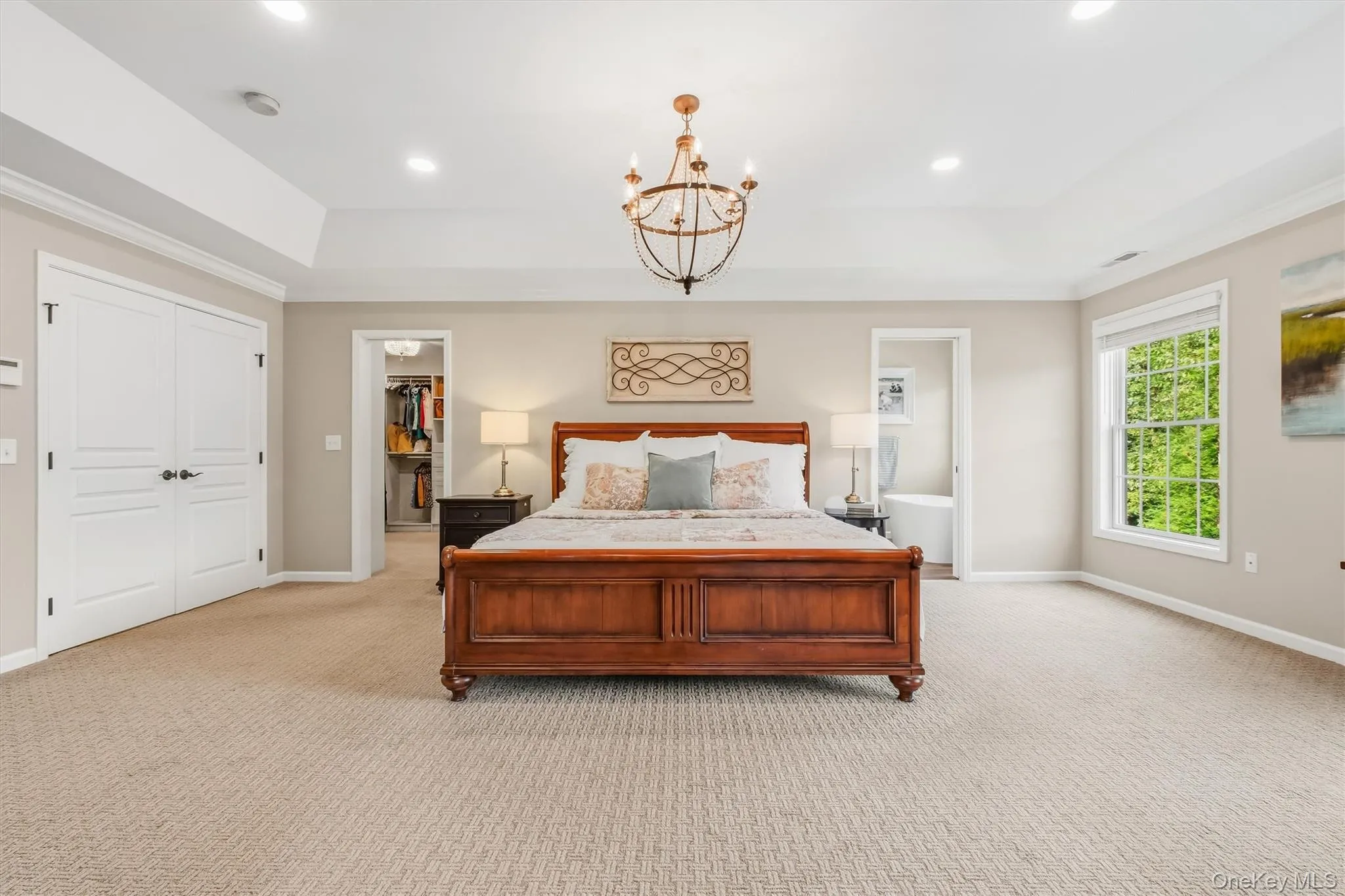 Experience elevated living in this beautifully designed primary suite, where generous space and refined style come together effortlessly. A soaring tray ceiling, recessed lighting, and an elegant chandelier create a serene ambiance, while expansive windows fill the room with natural light. Newer plush carpeting and fresh paint add a clean, sophisticated touch. The thoughtfully reconfigured layout features a custom his-and-hers dressing room designed for exceptional storage and organization. A separate private sitting room or media lounge provides the perfect place to relax and unwind, while the luxurious en-suite bathroom completes this tranquil retreat. Experience elevated living in this beautifully designed primary suite, where generous space and refined style come together effortlessly. A soaring tray ceiling, recessed lighting, and an elegant chandelier create a serene ambiance, while expansive windows fill the room with natural light. Newer plush carpeting and fresh paint add a clean, sophisticated touch. The thoughtfully reconfigured layout features a custom his-and-hers dressing room designed for exceptional storage and organization. A separate private sitting room or media lounge provides the perfect place to relax and unwind, while the luxurious en-suite bathroom completes this tranquil retreat.