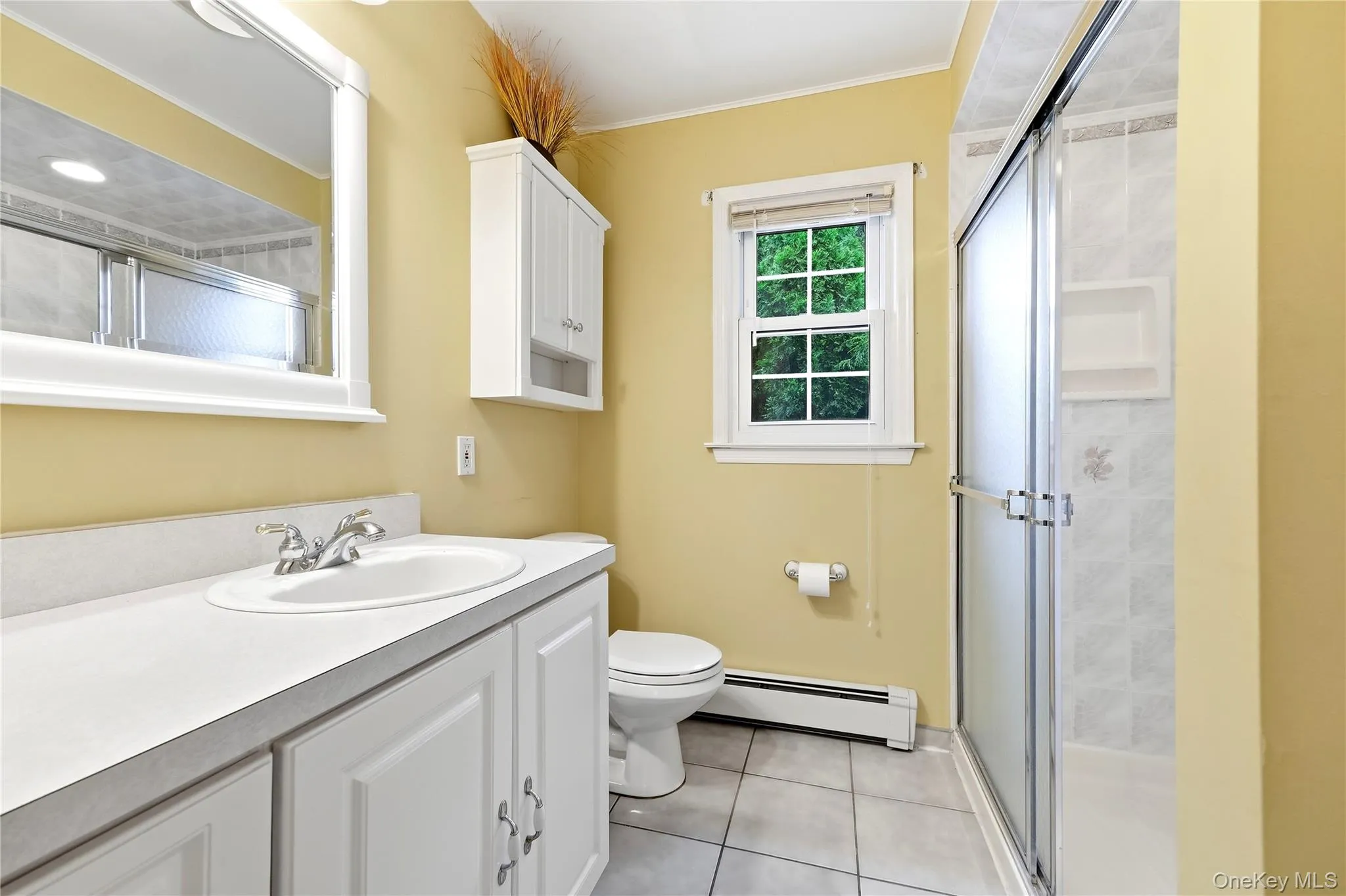 White vanity with a single basin sink, chrome faucet, walk in shower and ample countertop space White vanity with a single basin sink, chrome faucet, walk in shower and ample countertop space
