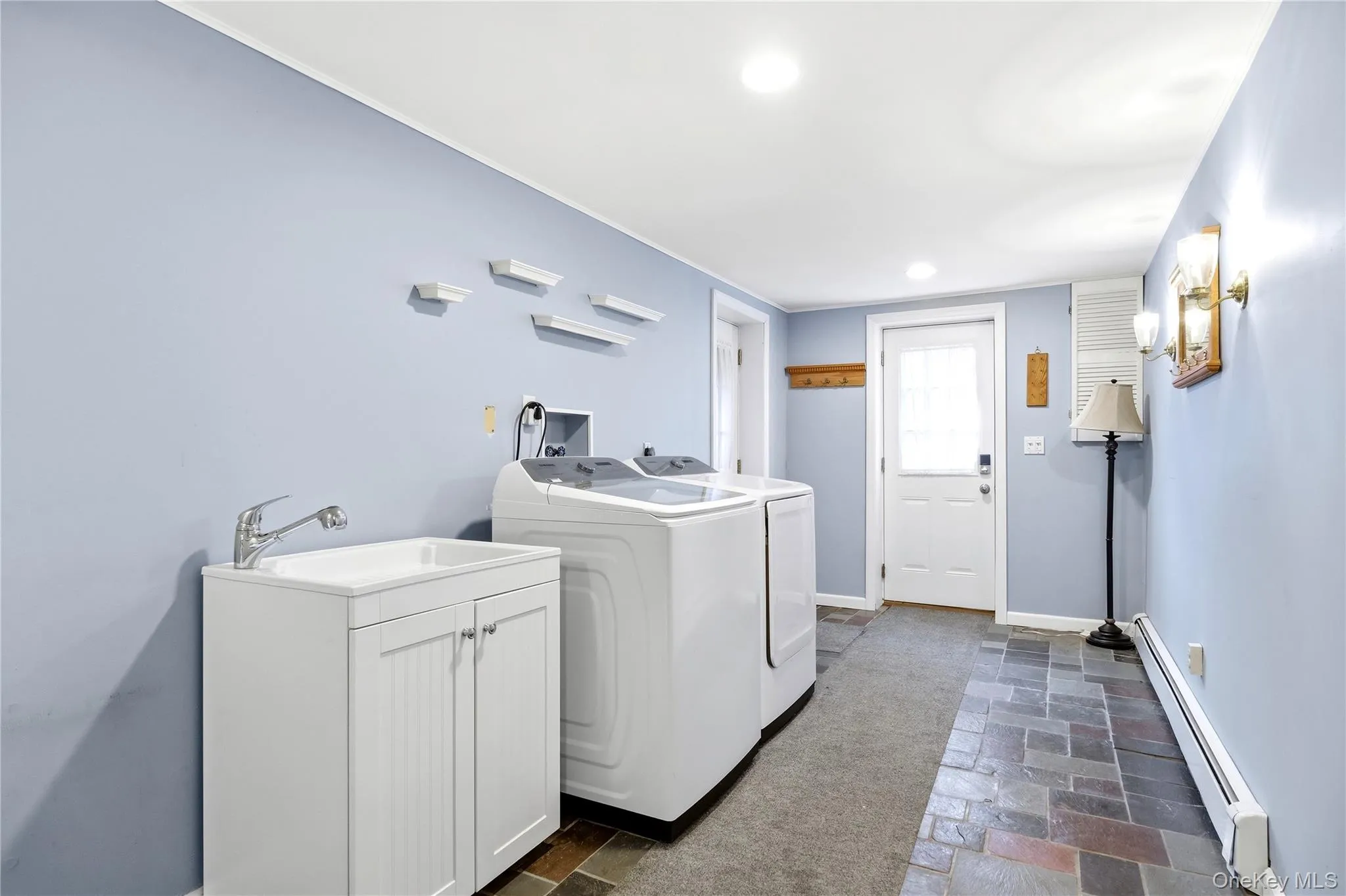laundry area with exterior exit featuring a utility sink and side-by-side washer and dryer laundry area with exterior exit featuring a utility sink and side-by-side washer and dryer