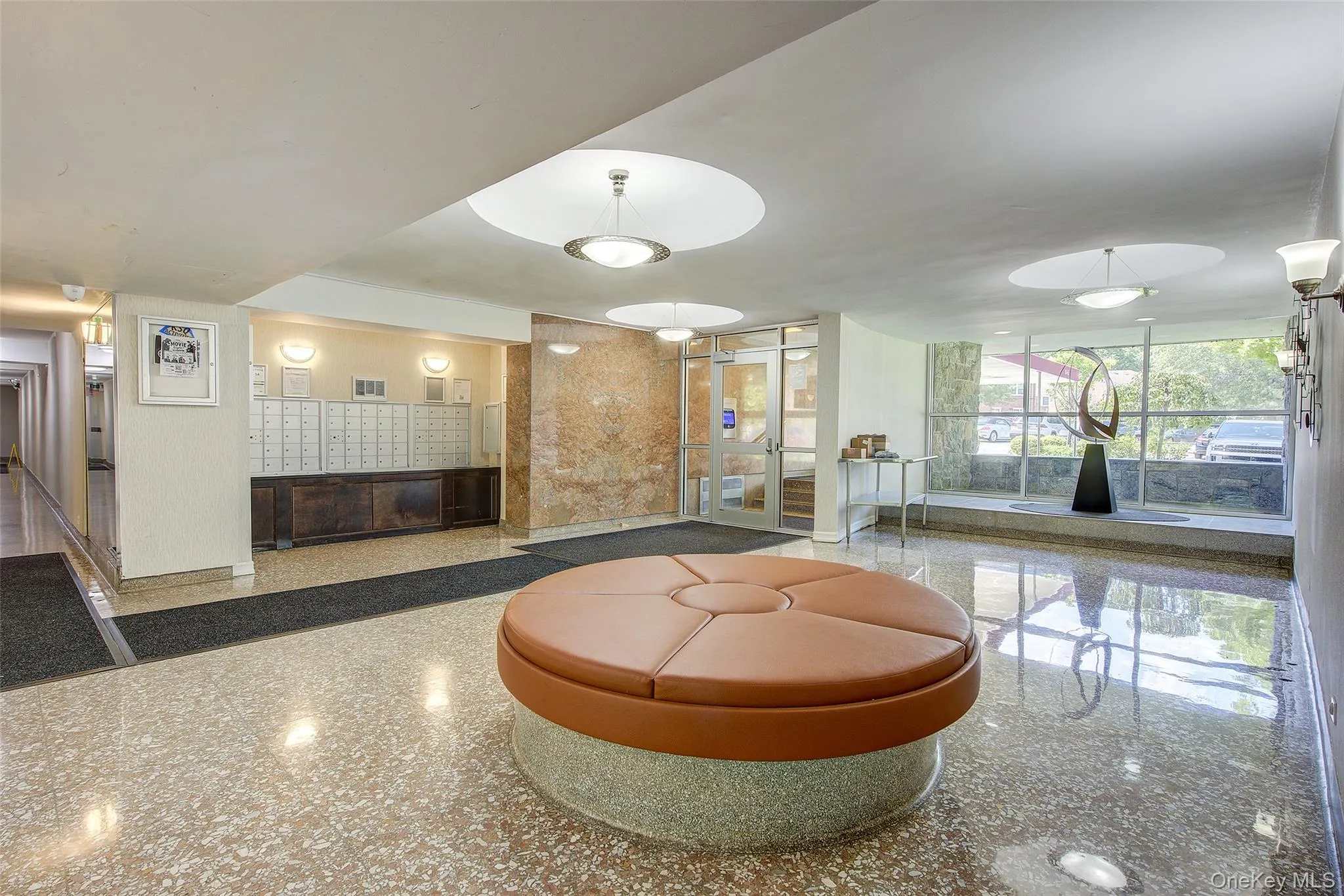 Lobby featuring stone tile flooring, a glass entrance, and wall-mounted mailboxes Lobby featuring stone tile flooring, a glass entrance, and wall-mounted mailboxes