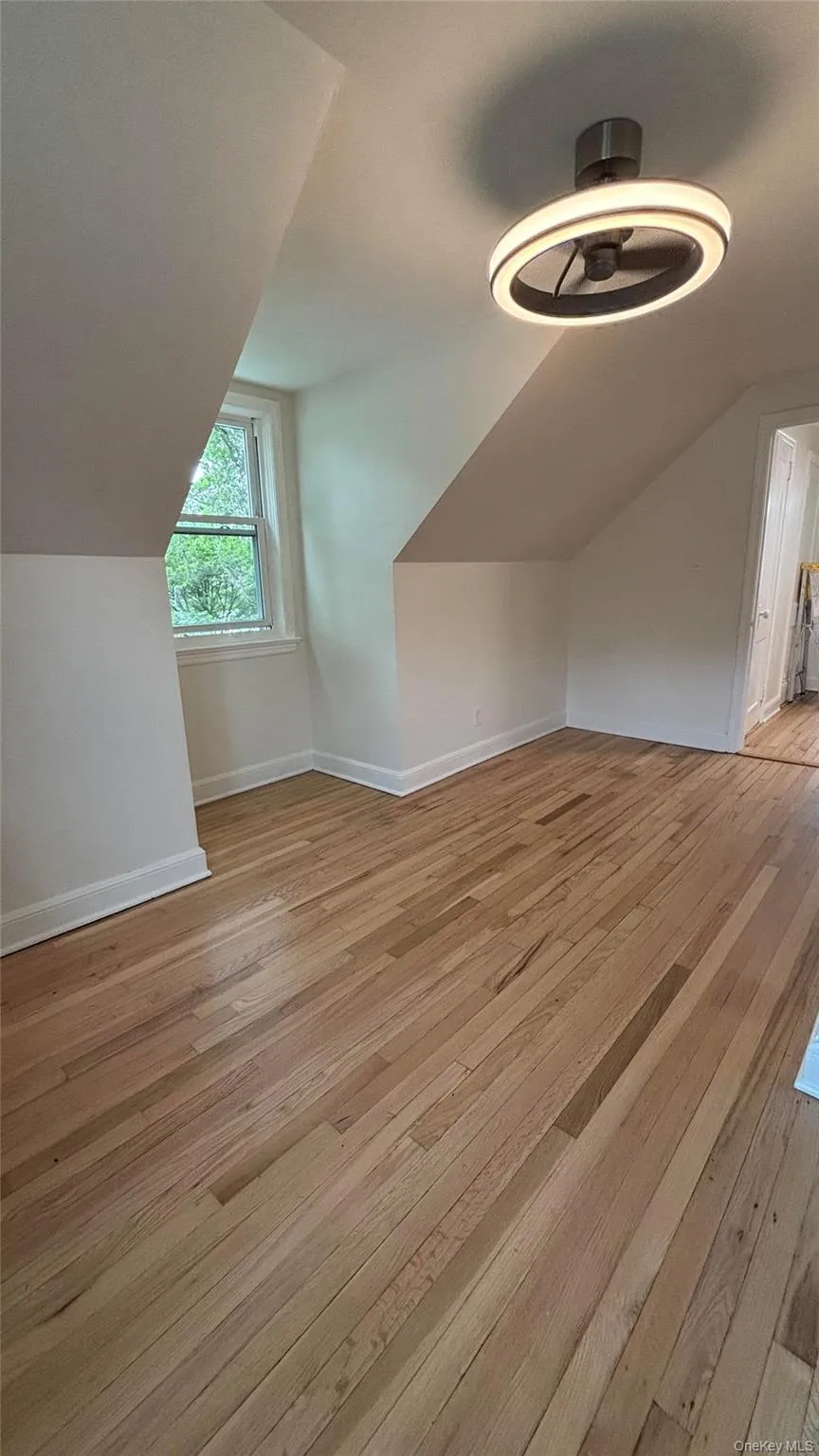 Additional living space with light wood-style flooring and lofted ceiling Additional living space with light wood-style flooring and lofted ceiling
