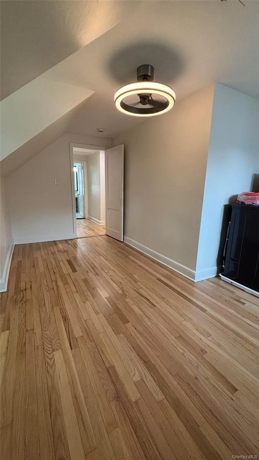 Unfurnished room with light wood finished floors and baseboards Unfurnished room with light wood finished floors and baseboards