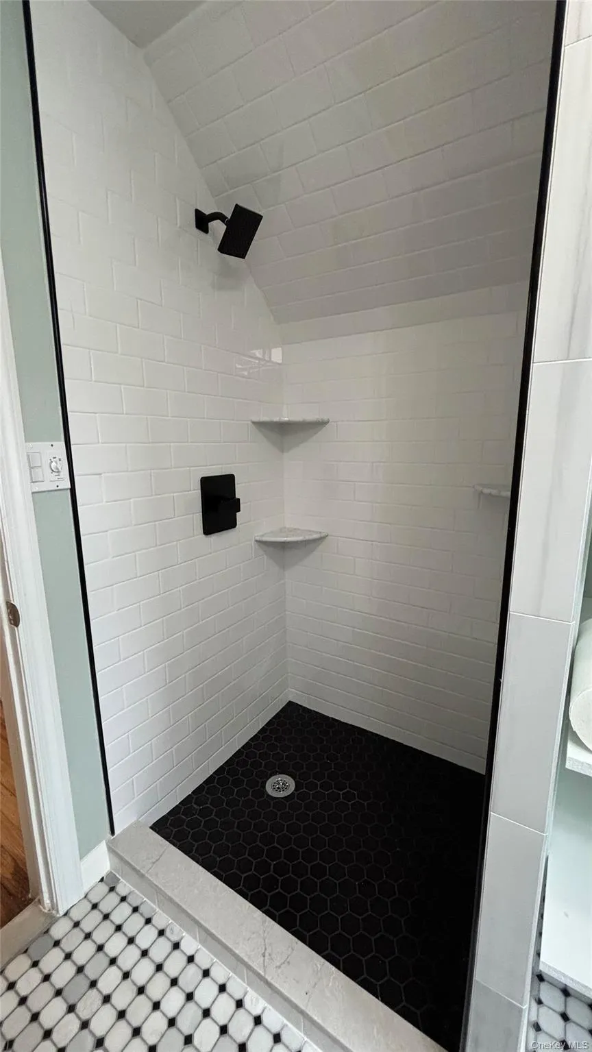 Bathroom featuring lofted ceiling and a stall shower Bathroom featuring lofted ceiling and a stall shower