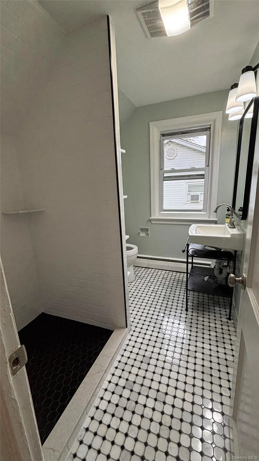Bathroom featuring a stall shower and lofted ceiling Bathroom featuring a stall shower and lofted ceiling