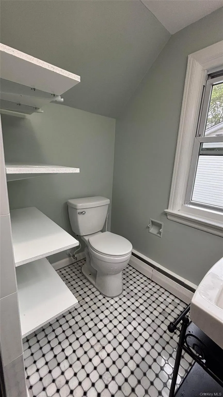 Bathroom with baseboard heating and vaulted ceiling Bathroom with baseboard heating and vaulted ceiling