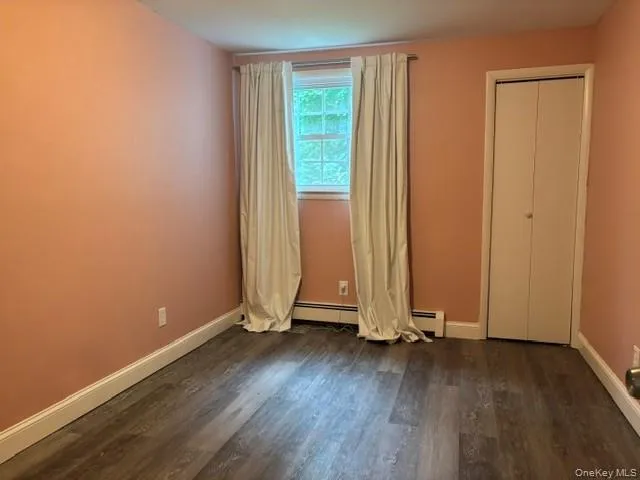 Laminate flooring, single window, white trim, and a bi-fold closet door Laminate flooring, single window, white trim, and a bi-fold closet door
