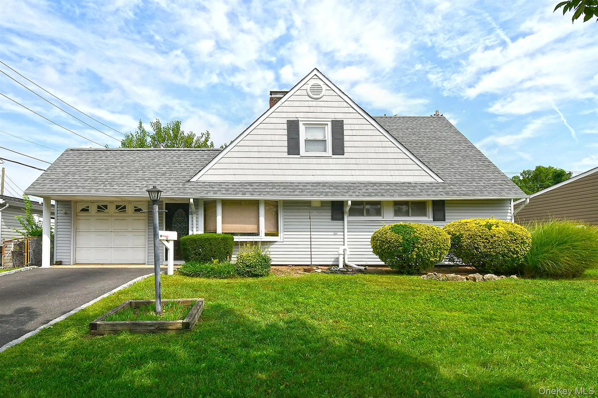 Single-story residence featuring light-colored siding and a gabled roof Single-story residence featuring light-colored siding and a gabled roof