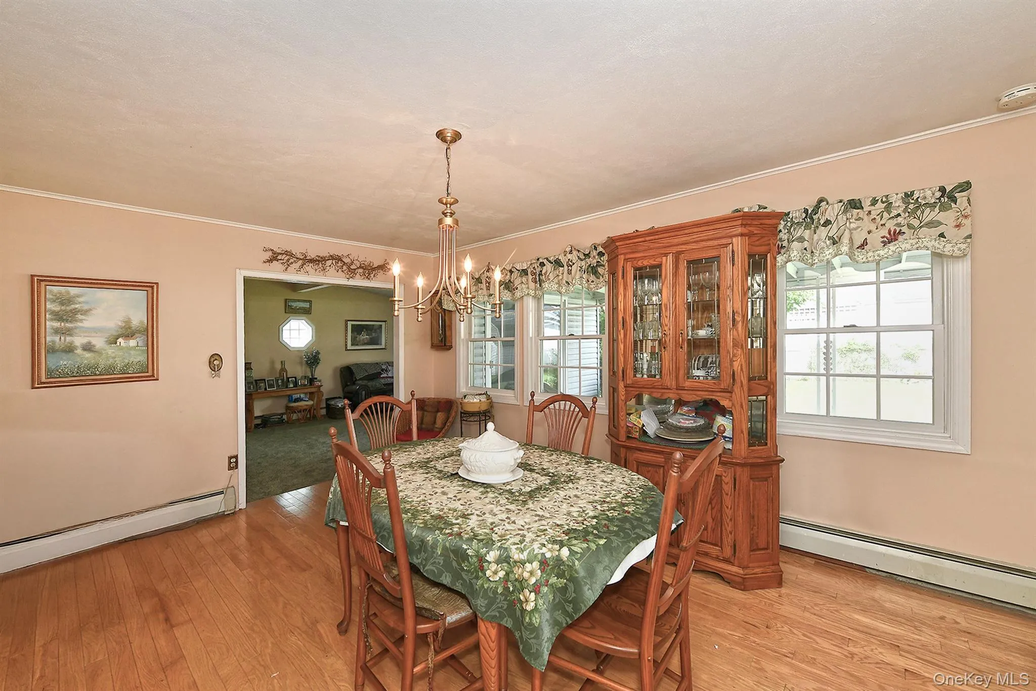Wood-finish flooring, multiple windows, chandelier, and crown molding Wood-finish flooring, multiple windows, chandelier, and crown molding