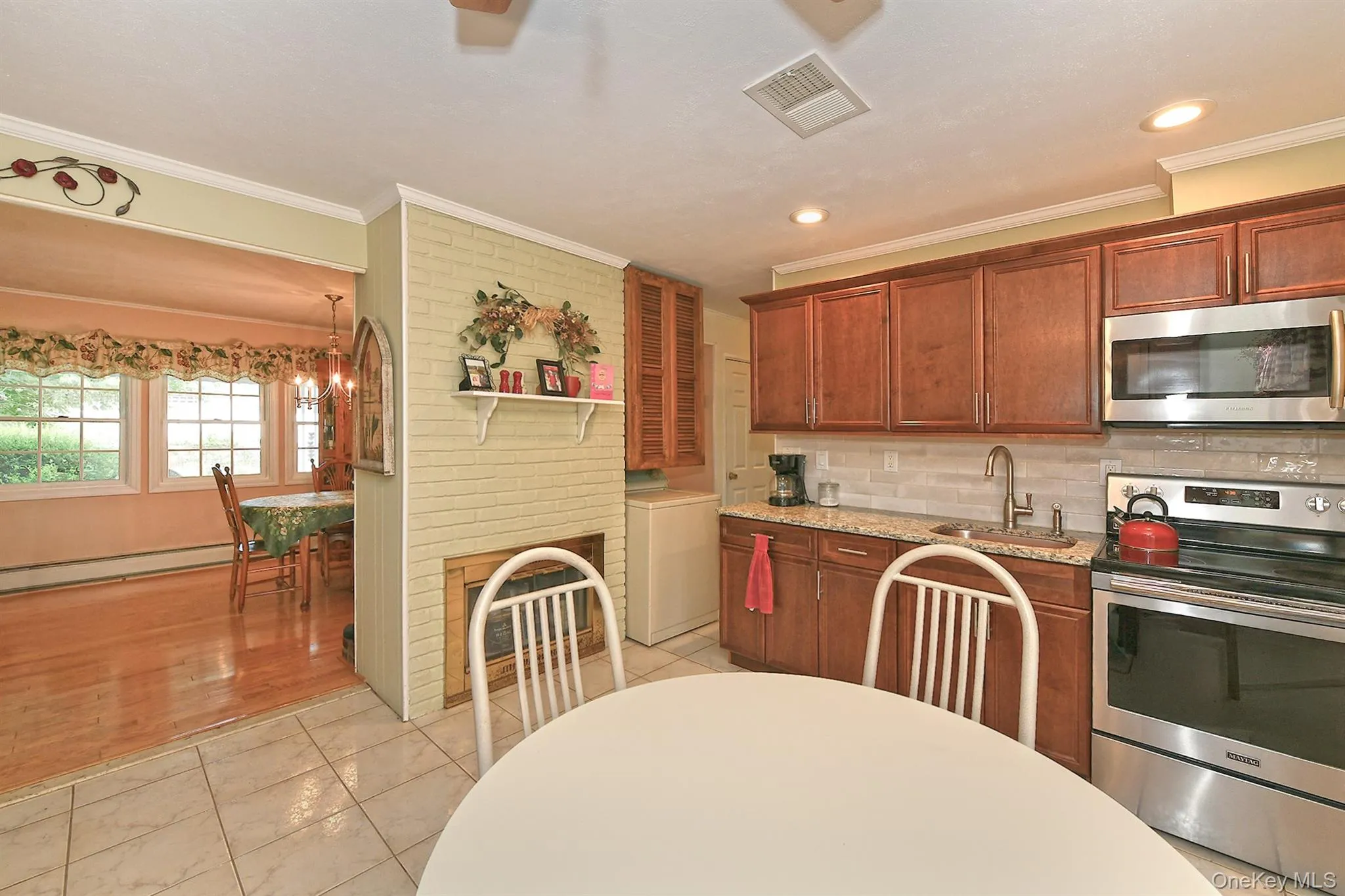 Kitchen with wood cabinetry, granite-style countertops, stainless steel appliances, and a tiled backsplash Kitchen with wood cabinetry, granite-style countertops, stainless steel appliances, and a tiled backsplash