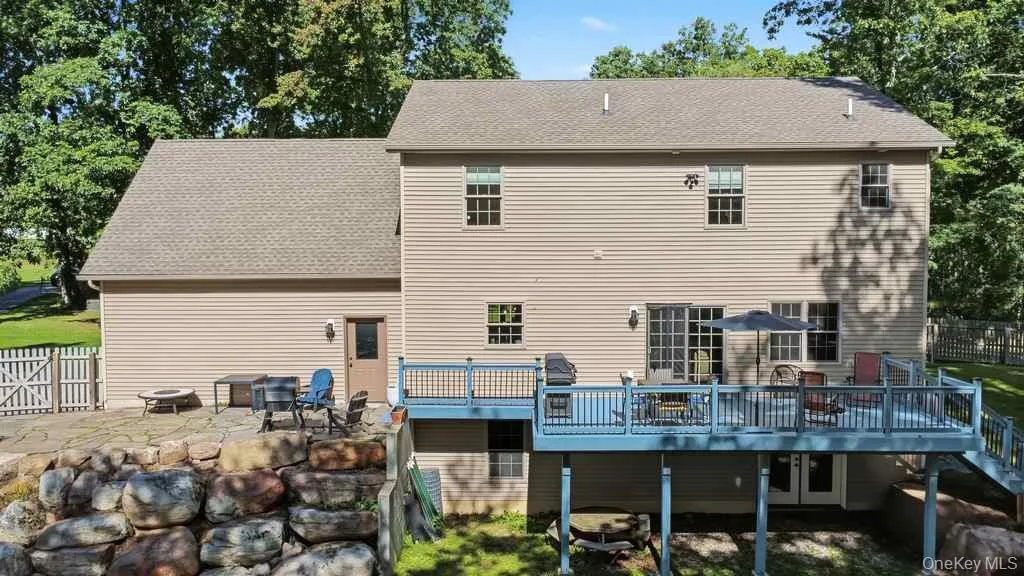 Large elevated rear deck with surrounding trees and a stone retaining wall Large elevated rear deck with surrounding trees and a stone retaining wall