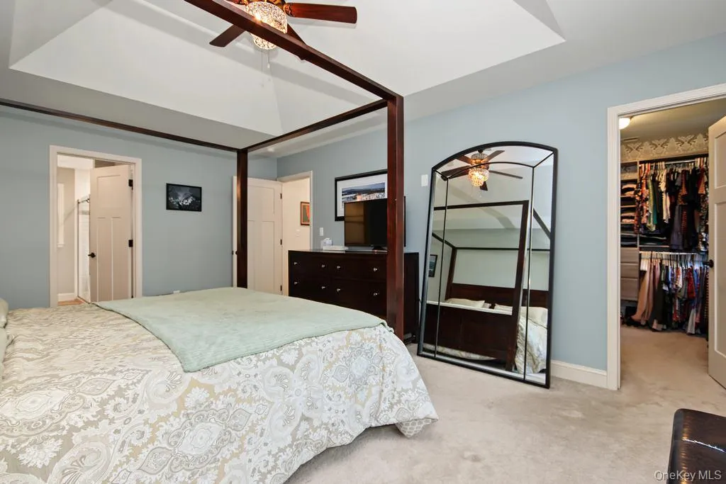 carpeted flooring, and a walk-in closet with built-in shelving carpeted flooring, and a walk-in closet with built-in shelving