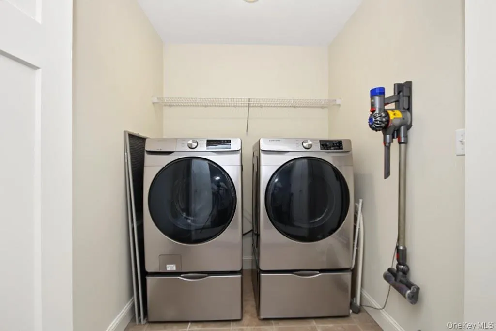 Dedicated 2nd floor laundry area featuring a front-loading washer and dryer set Dedicated 2nd floor laundry area featuring a front-loading washer and dryer set