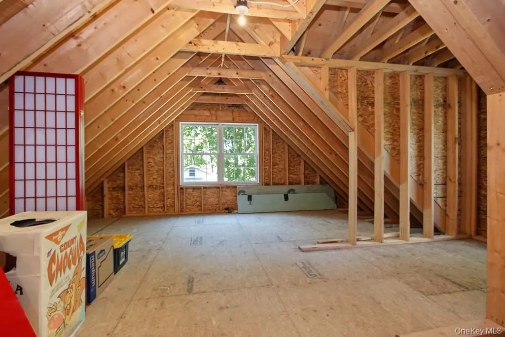 Exposed wood beam construction, unfinished flooring, window, and wood framing Exposed wood beam construction, unfinished flooring, window, and wood framing