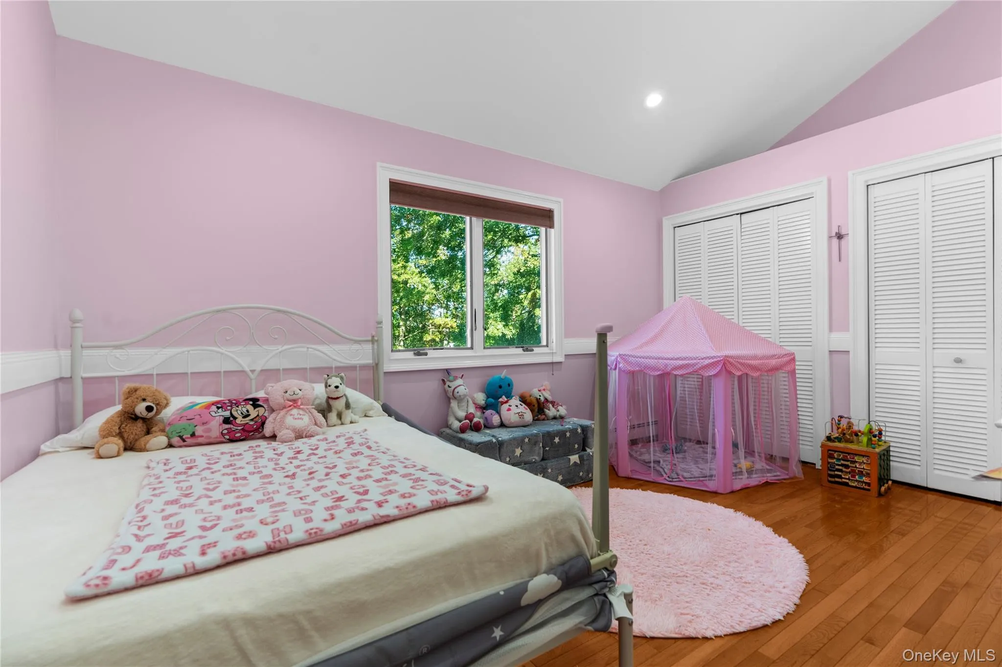 Bedroom with vaulted ceiling, wood-type flooring, two closets, and recessed lighting Bedroom with vaulted ceiling, wood-type flooring, two closets, and recessed lighting