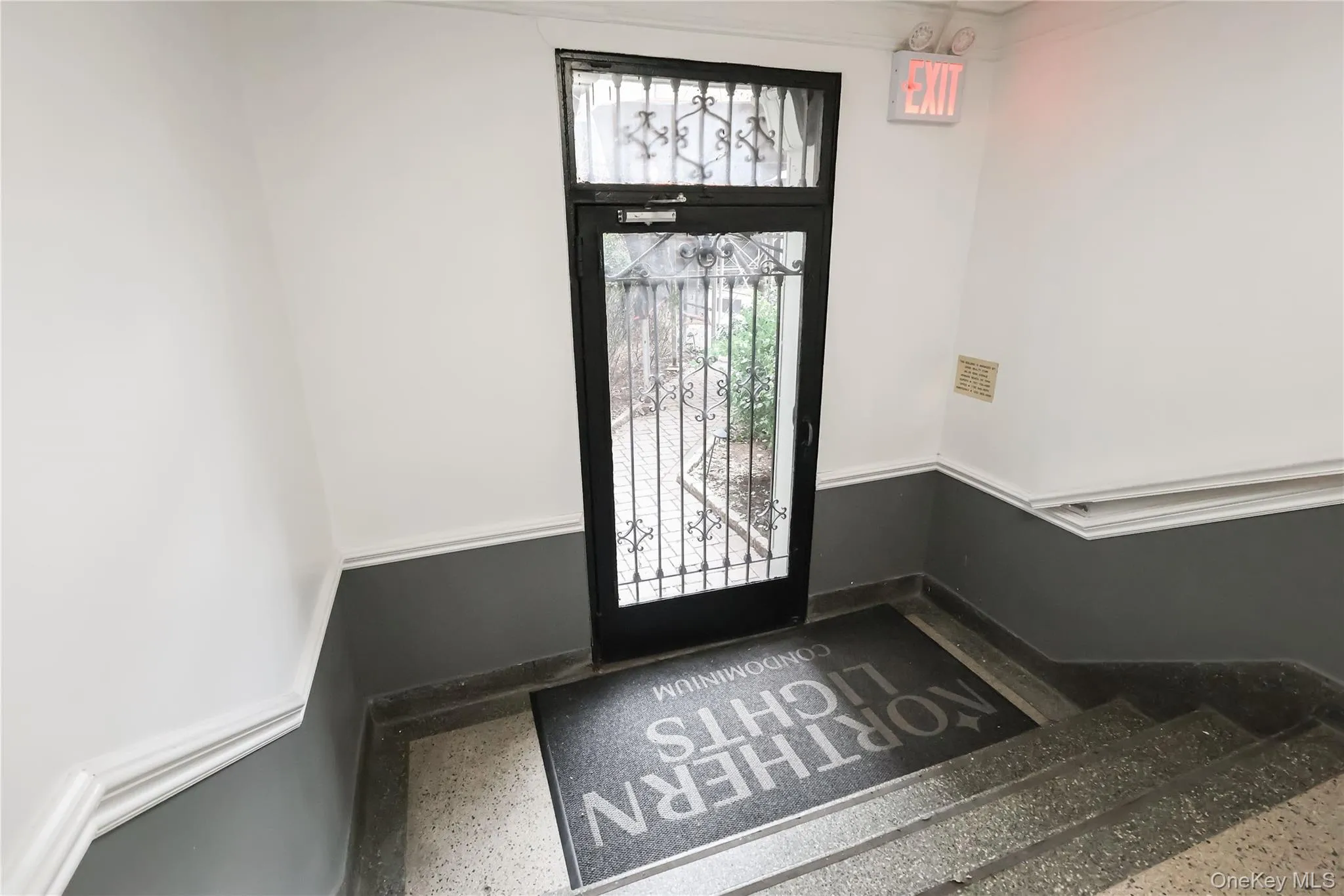 Glass-paneled entry door with decorative ironwork and transom window Glass-paneled entry door with decorative ironwork and transom window