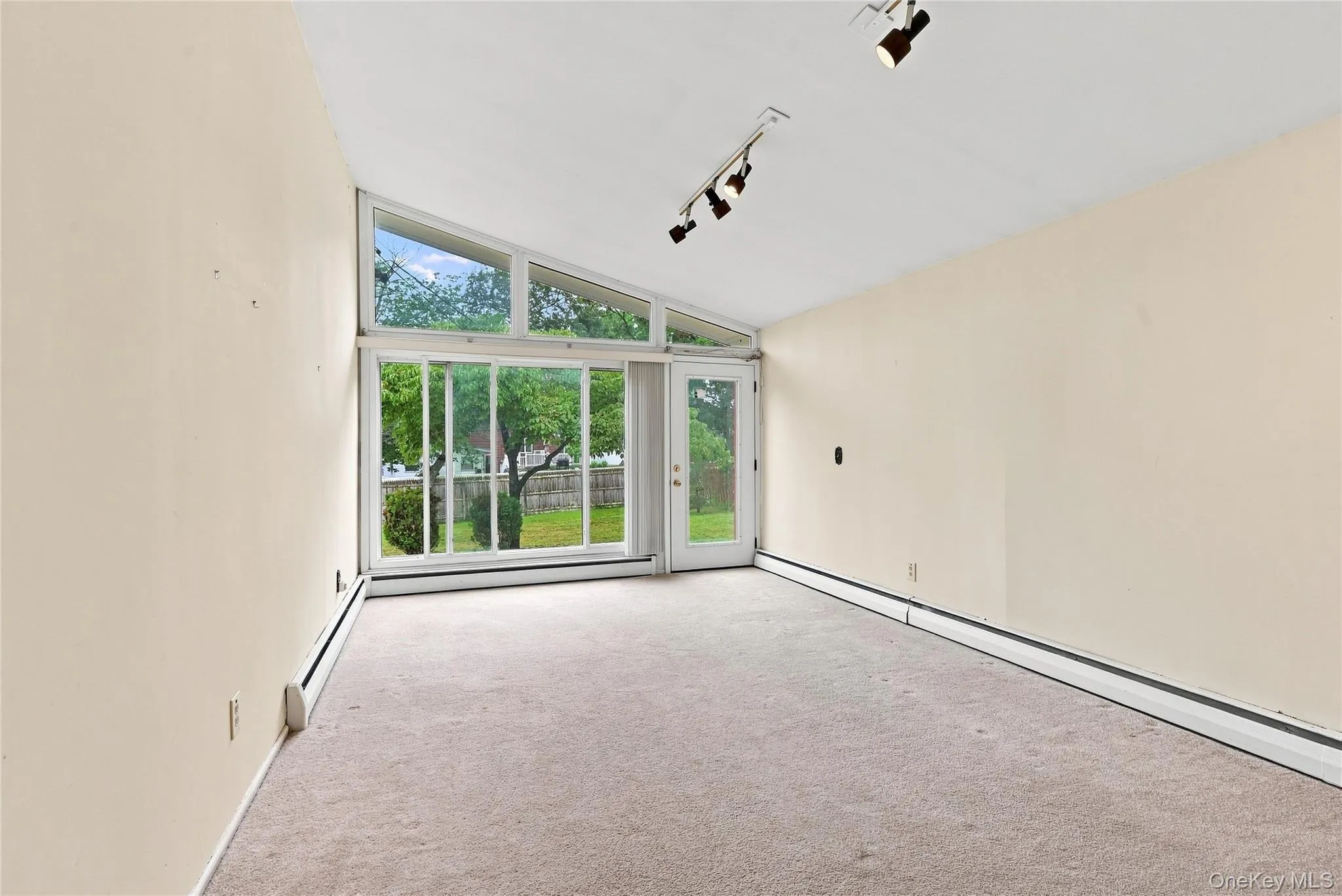 Stunning wall of windows with a door leading to the fenced yard Stunning wall of windows with a door leading to the fenced yard