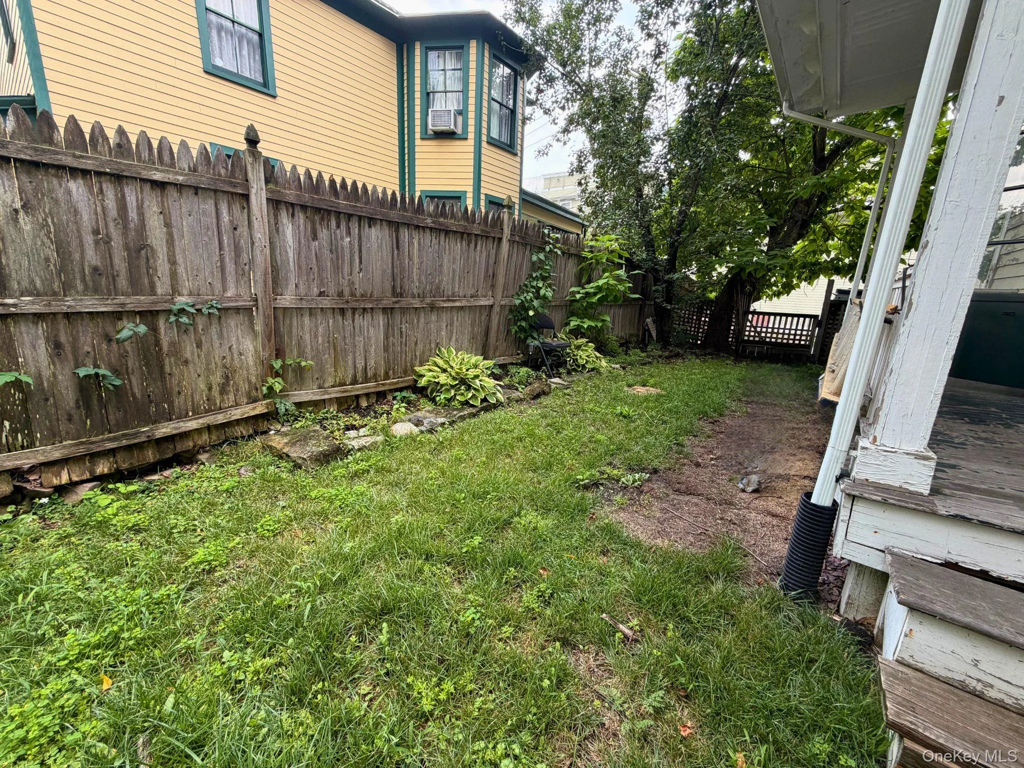 Private fenced yard with established perimeter plantings and mature trees Private fenced yard with established perimeter plantings and mature trees