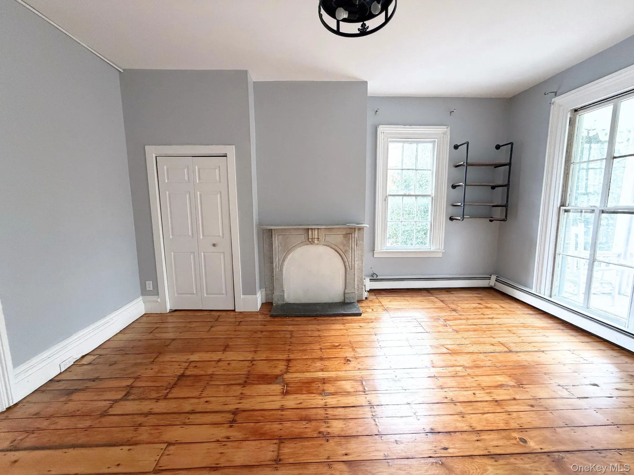 Wood-finish flooring, decorative fireplace, multiple windows, built-in shelving, and bi-fold closet doors Wood-finish flooring, decorative fireplace, multiple windows, built-in shelving, and bi-fold closet doors