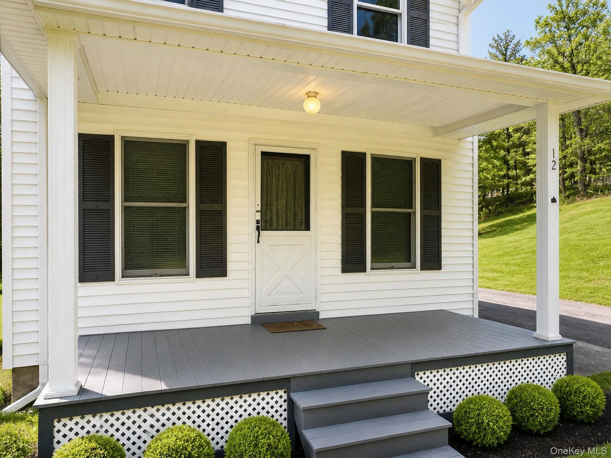 Inviting front porch featuring a gray-painted deck and matching steps Inviting front porch featuring a gray-painted deck and matching steps
