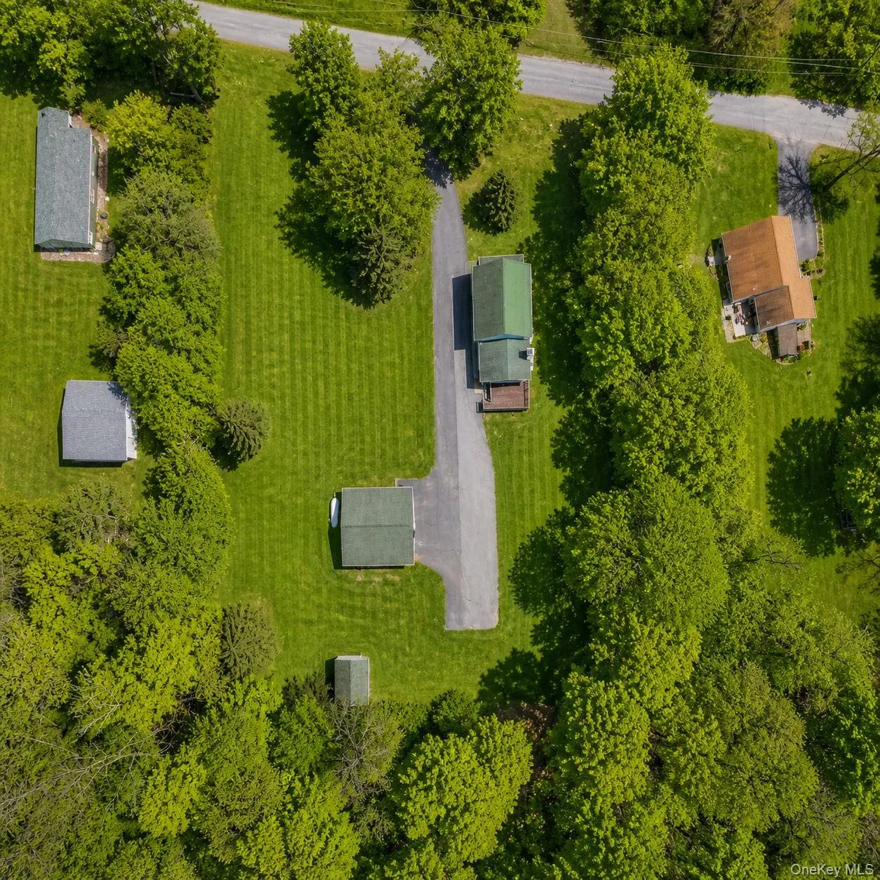 Aerial view showcasing multiple structures surrounded by expansive green lawns and mature trees Aerial view showcasing multiple structures surrounded by expansive green lawns and mature trees