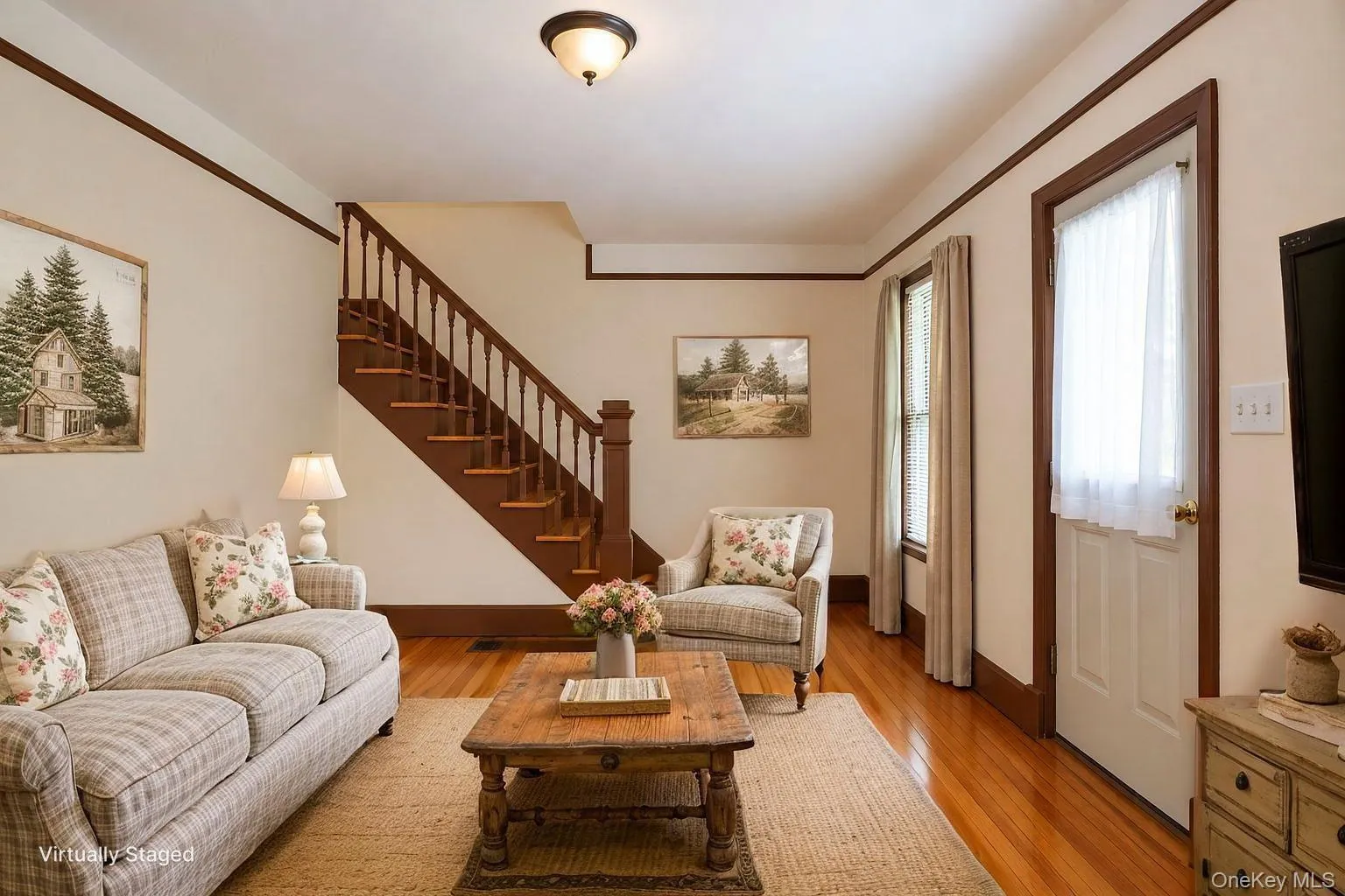 Rich wood-finish flooring complements the dark wood trim and staircase, contrasting with light-colored walls Rich wood-finish flooring complements the dark wood trim and staircase, contrasting with light-colored walls