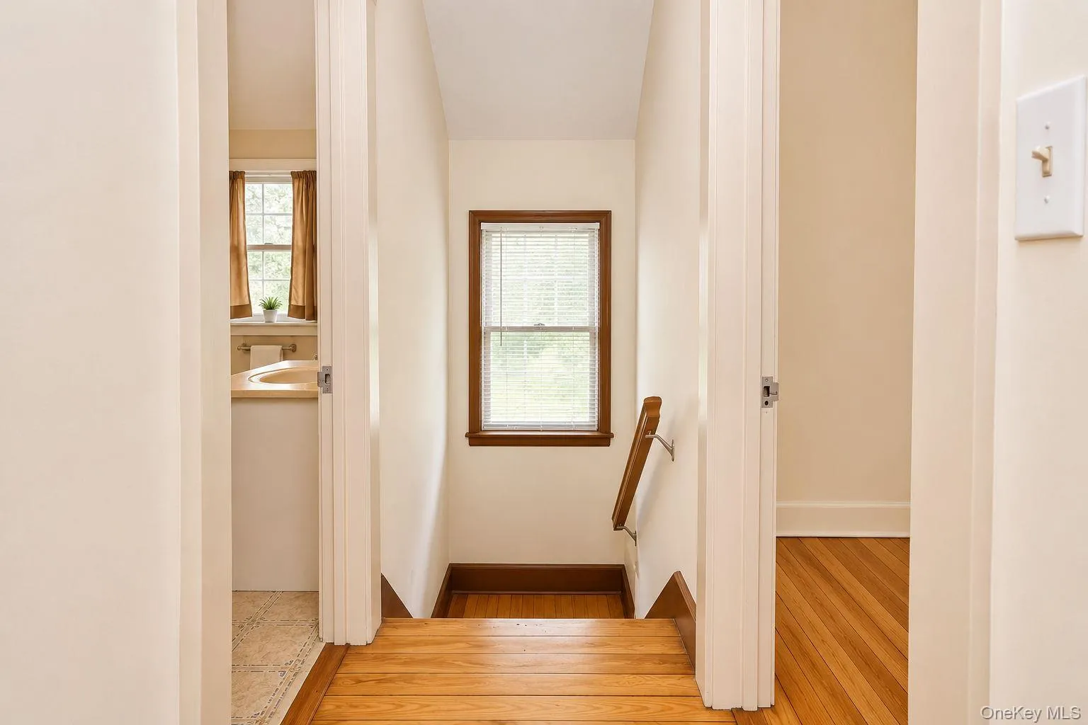 Hardwood flooring extends throughout this upper level, featuring natural wood trim around the window and along the baseboards Hardwood flooring extends throughout this upper level, featuring natural wood trim around the window and along the baseboards