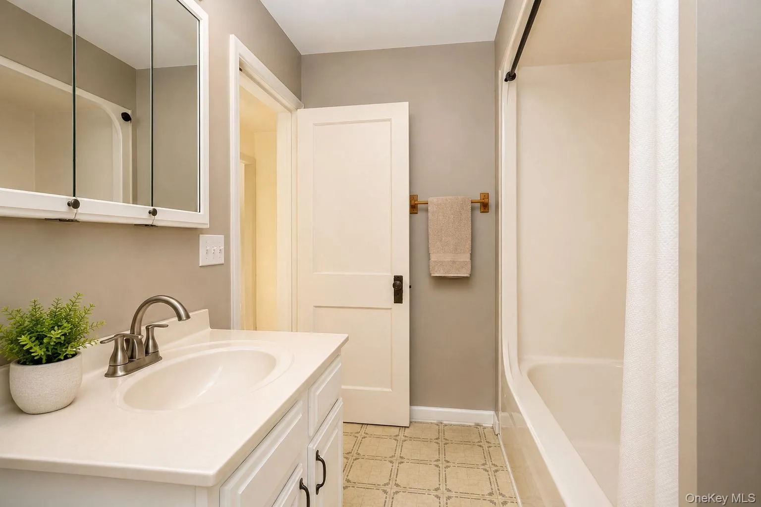 White vanity with an integrated sink and brushed nickel faucet White vanity with an integrated sink and brushed nickel faucet