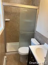 Shower with sliding glass enclosure, floor-to-ceiling tile, and white shower pan Shower with sliding glass enclosure, floor-to-ceiling tile, and white shower pan