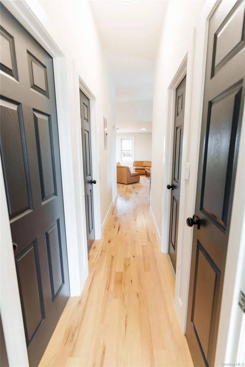 Hallway featuring light wood-type flooring and baseboards Hallway featuring light wood-type flooring and baseboards
